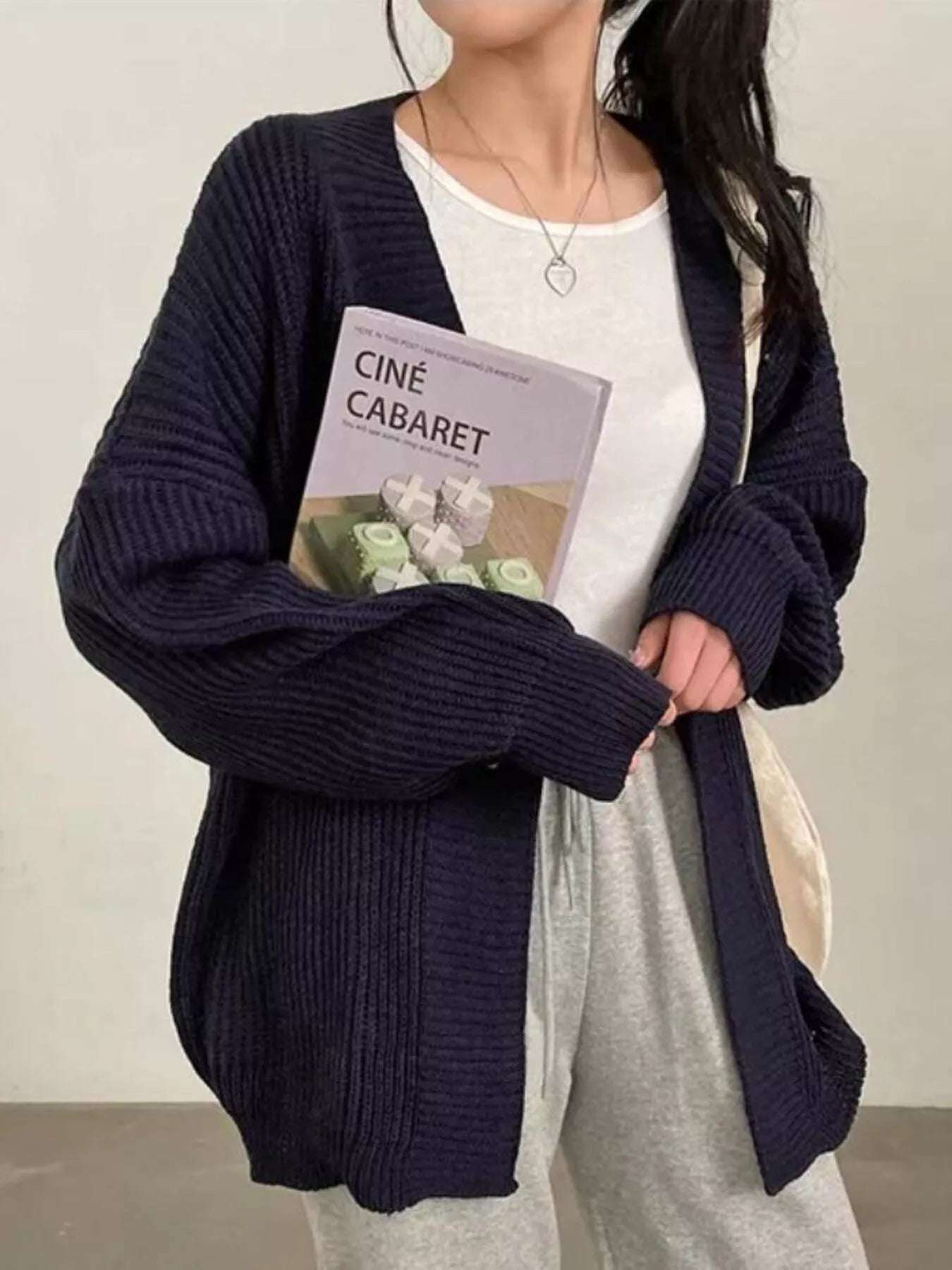 Open Front Oversized Knit Cardigan for Women worn by model holding a book in a cozy indoor setting.