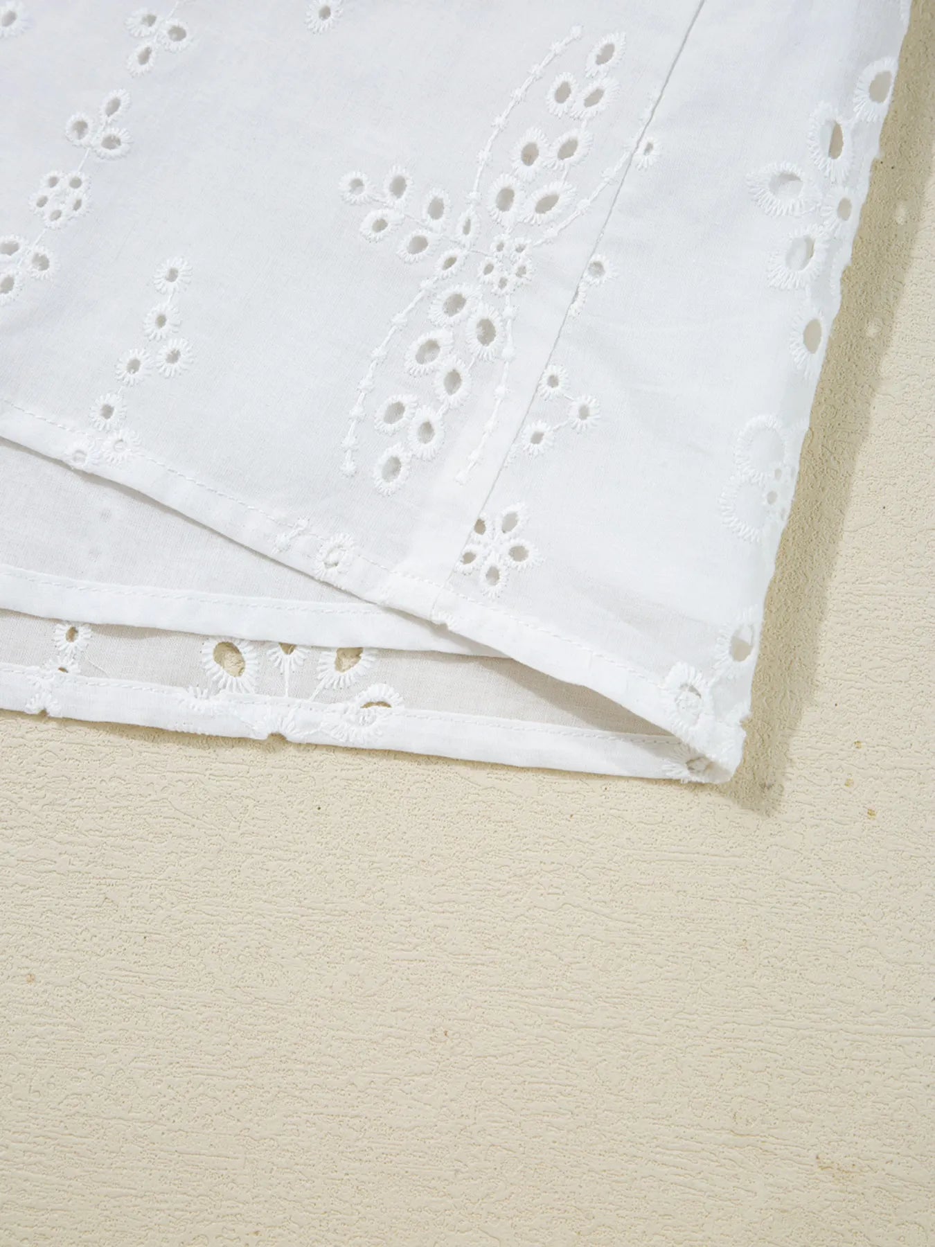 Eyelet Long Sleeve Blouse with Elastic Cuffs fabric detail showcasing intricate eyelet design and hemline.