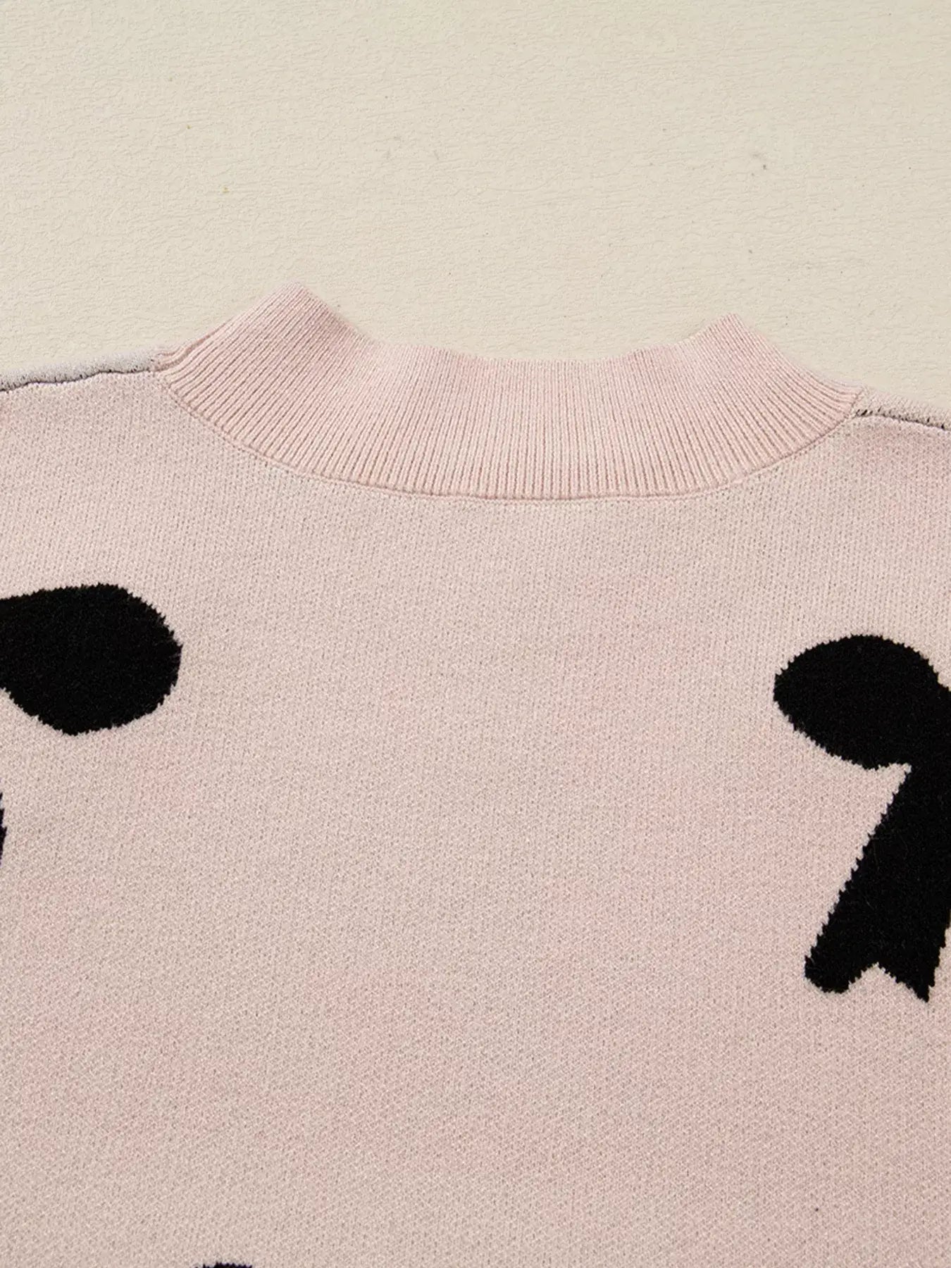 Back view of pearl embellished bow pattern loose sweater showing the soft knit and bow design details.