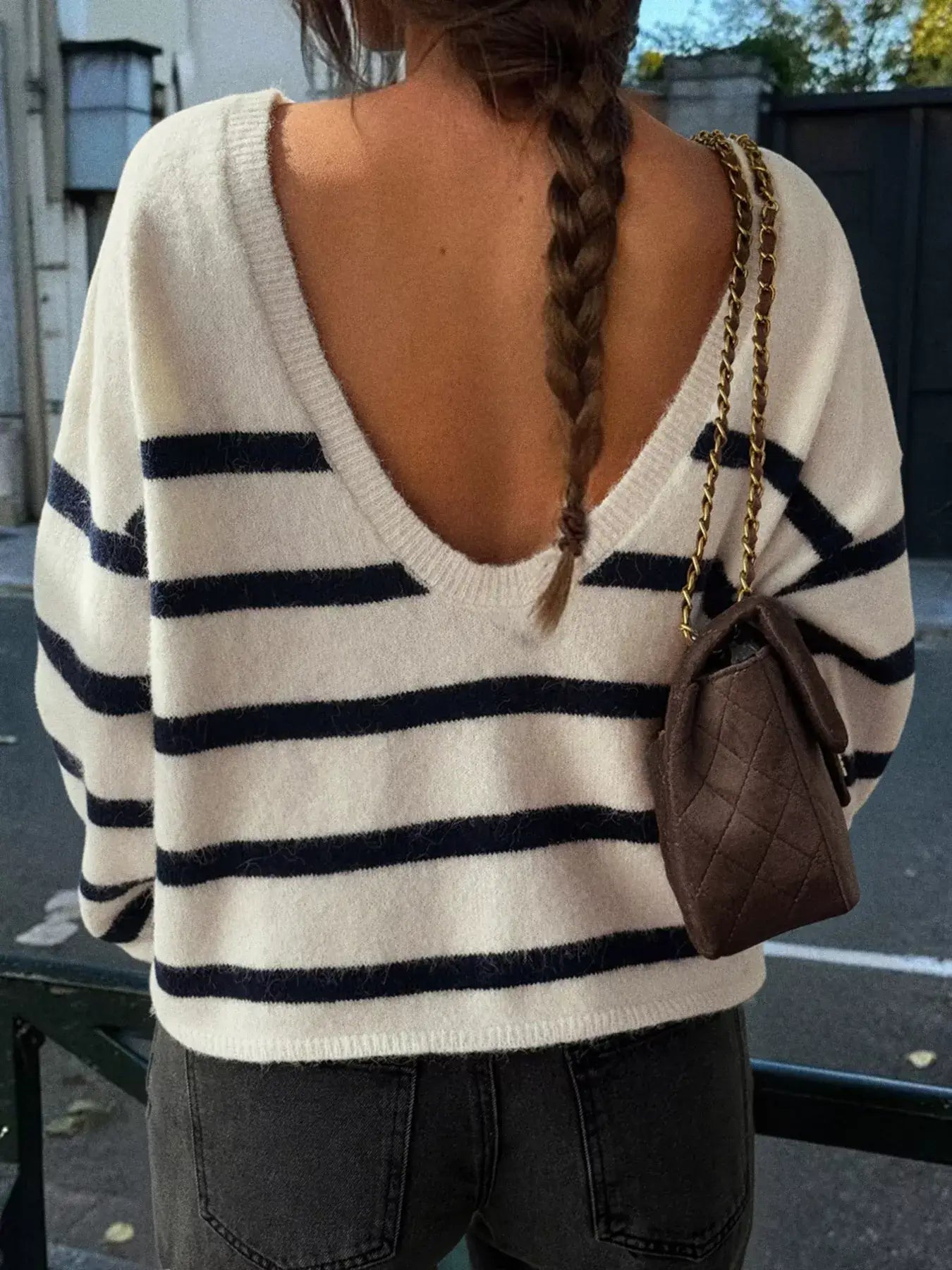Striped round neck long sleeve knit top with a V-back, showcasing a casual chic style.