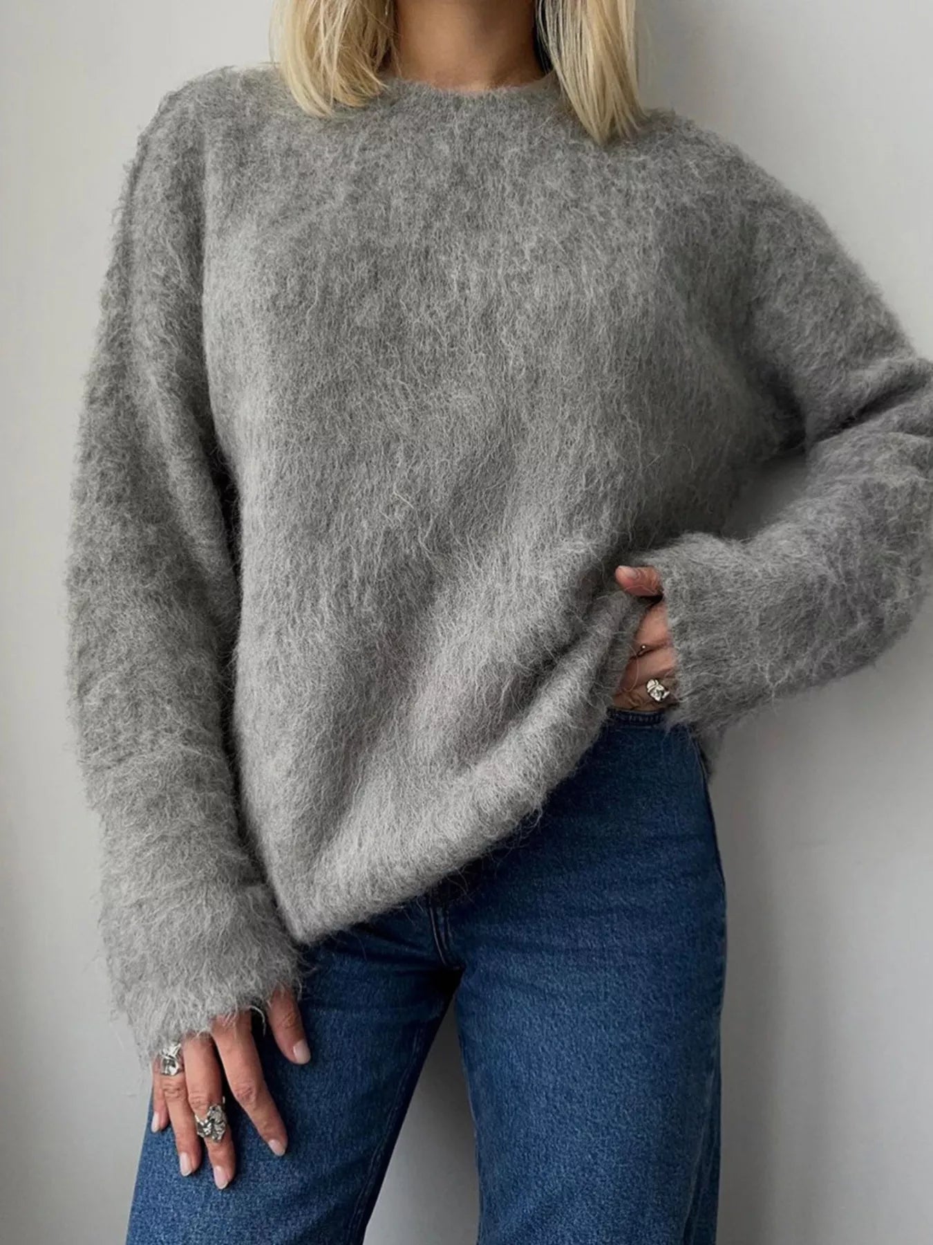 Fuzzy Round Neck Long Sleeve Sweater in gray worn with jeans, showcasing its cozy and slightly stretchy style.