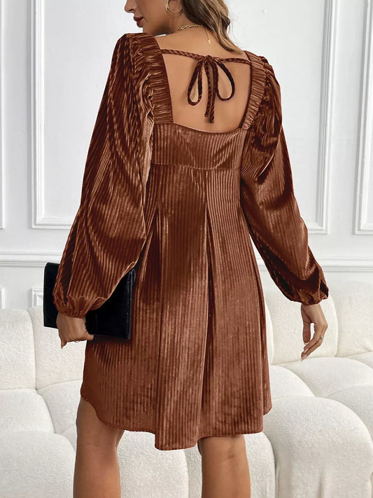 Back view of a model wearing a Velvet Square Neck Long Sleeve Dress in rich brown with ruffled details and long sleeves.
