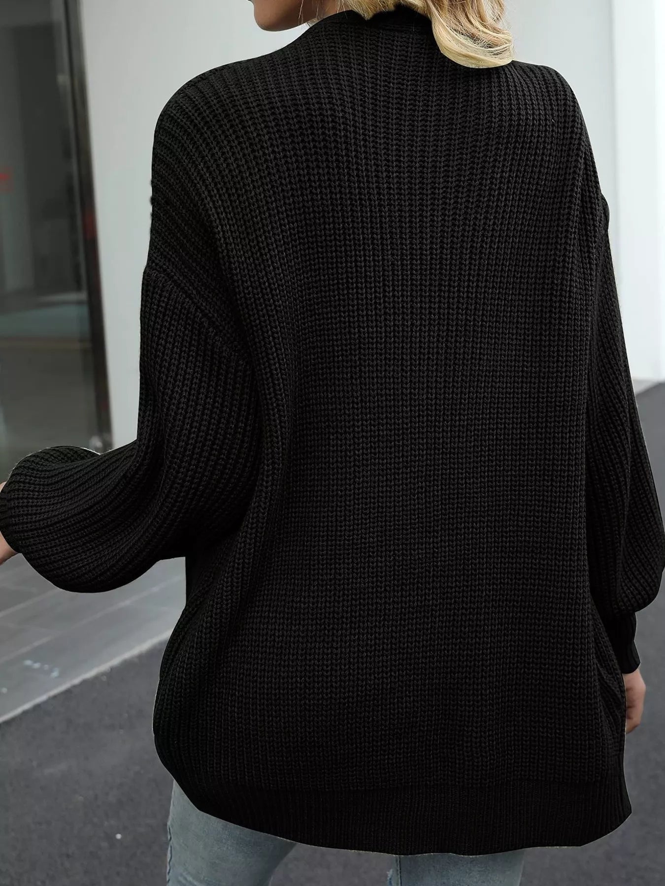 Back view of a model wearing a Chunky Knit Open Front Cardigan in black, showcasing its oversized cozy style.
