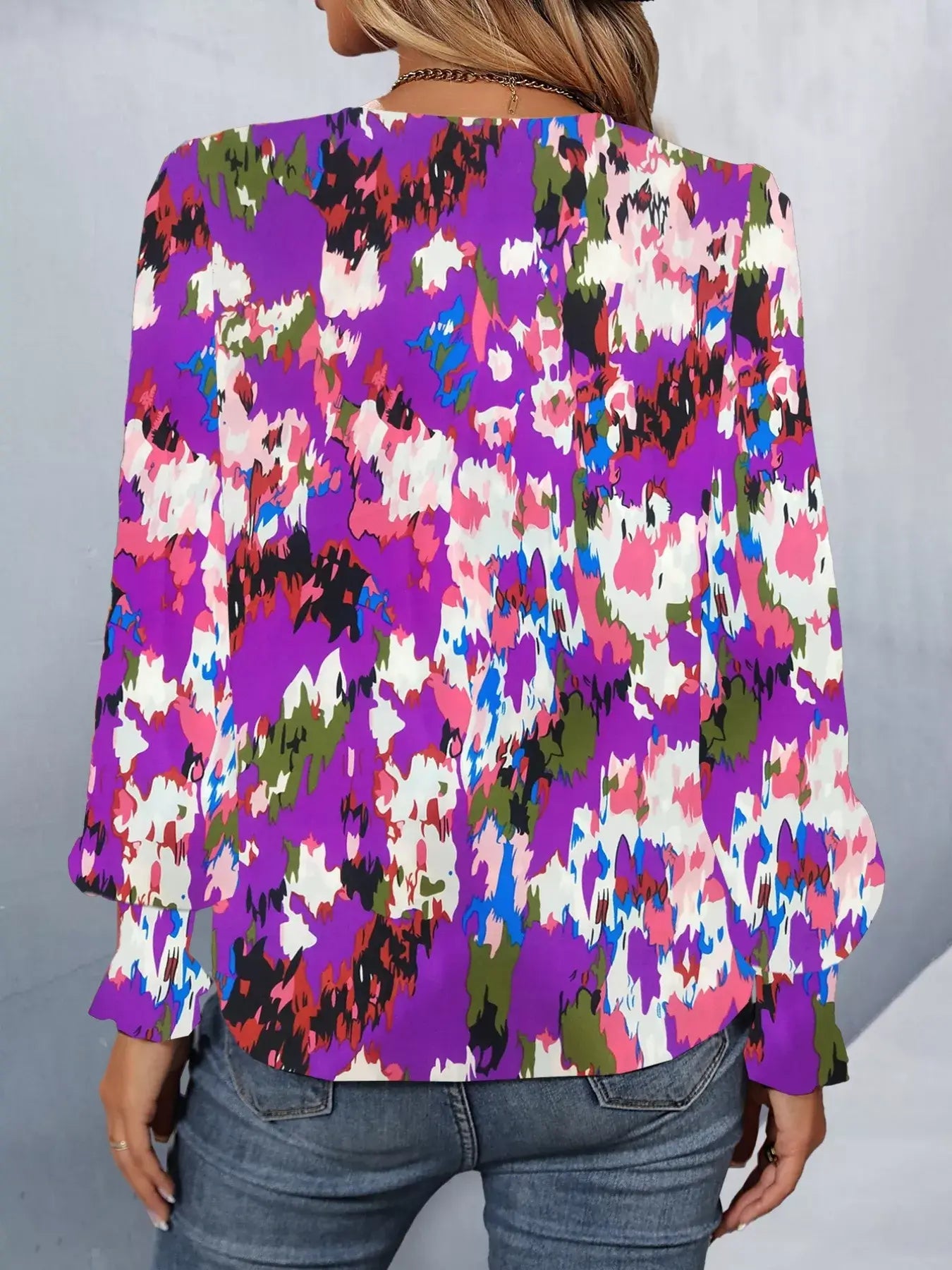 Back view of a printed button up long sleeve shirt in vibrant colors, showcasing floral patterns and long sleeves.