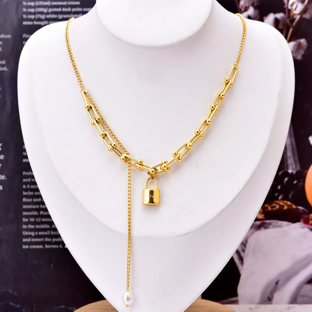 18K Gold-Plated Lock Pendant Necklace displayed on a white bust against a stylish backdrop.