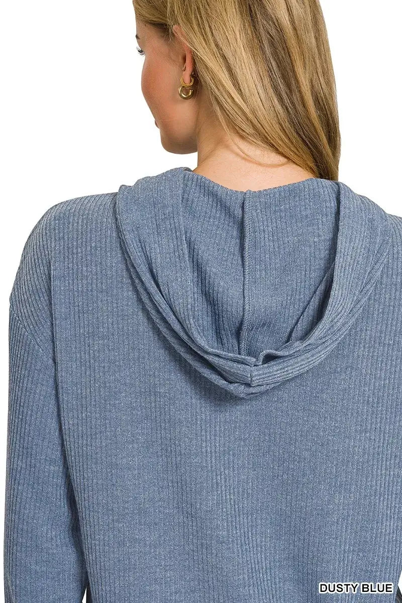 A woman wearing the Zenana Ribbed Long Sleeve Hoodie in dusty blue, showcasing the hood and ribbed texture.