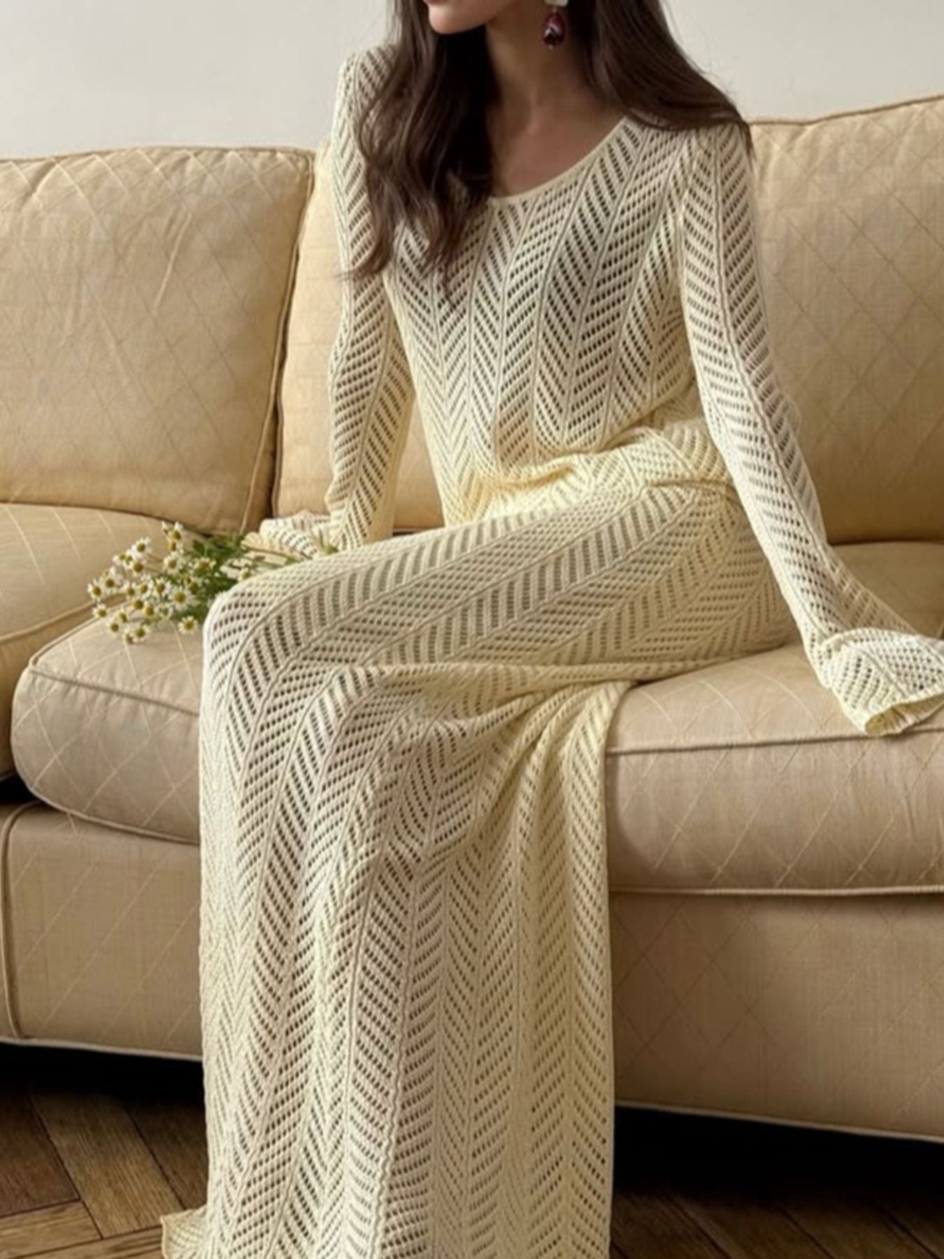 Openwork Long Sleeve Knit Top and Skirt Set elegant women outfit in a light yellow color, worn while sitting on a couch.