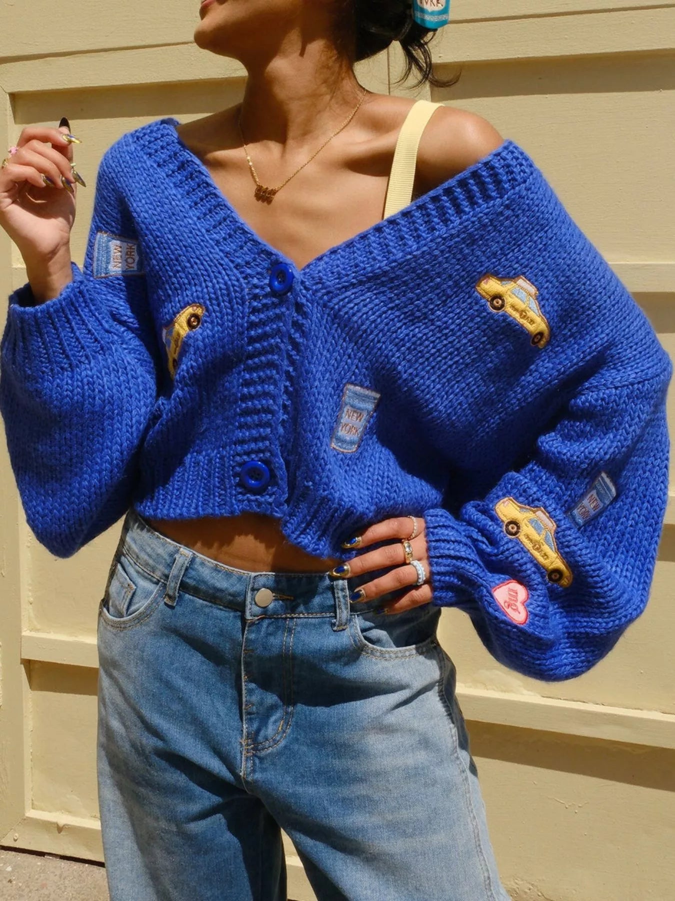 Embroidered Button Up Cardigan for Women in blue with colorful patches, styled with high-waisted jeans.