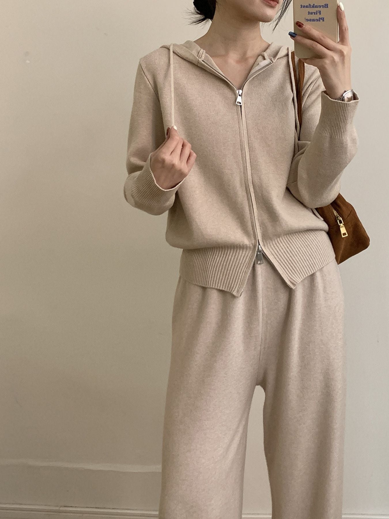 Woman wearing a Zip Up Cardigan and Wide Leg Pants Knit Set in beige, showcasing zipper and drawstring features.