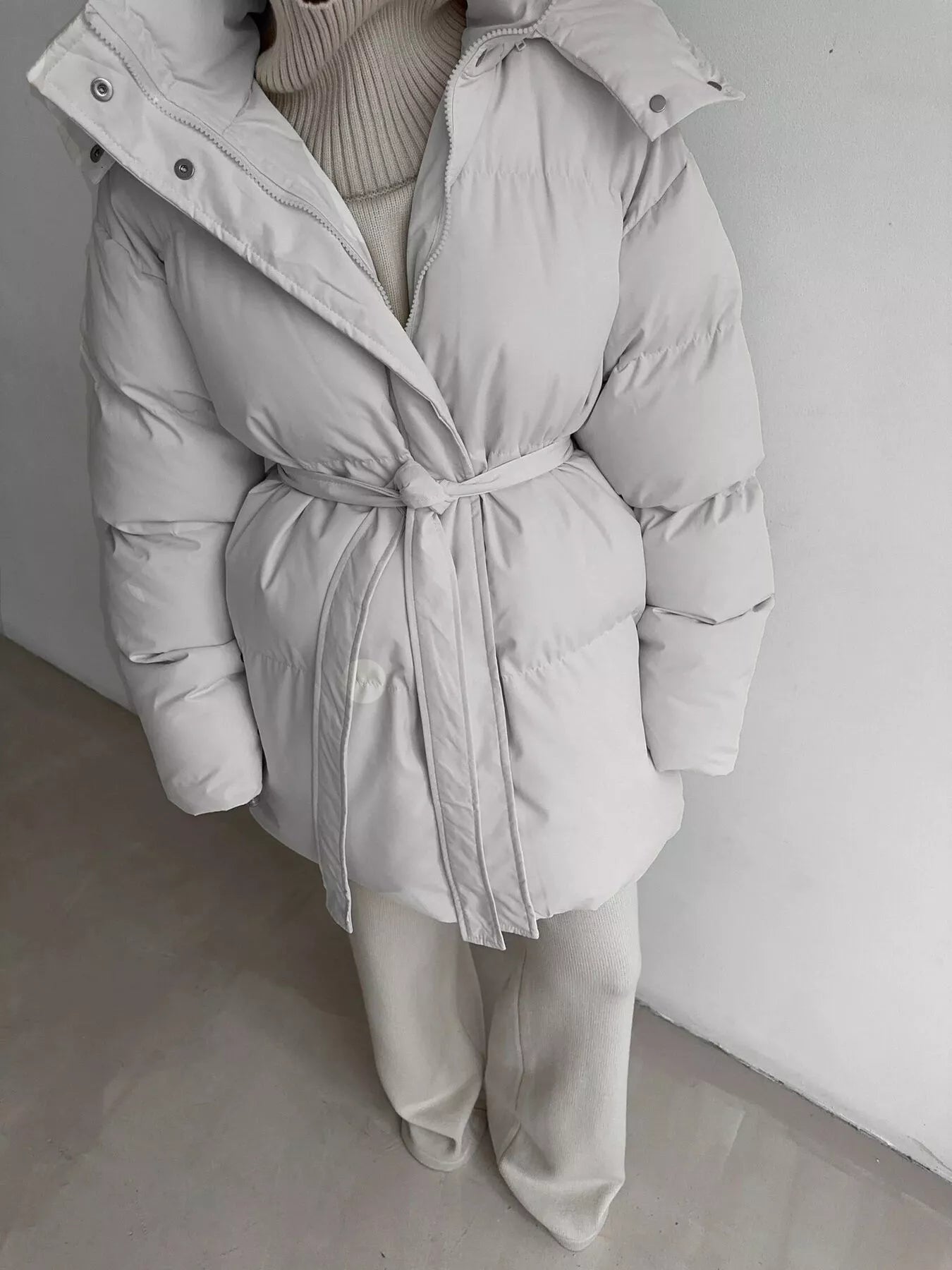 Mid Length Hooded Winter Coat Belted Warm Women Jacket in light gray color with a belted waist and pockets.