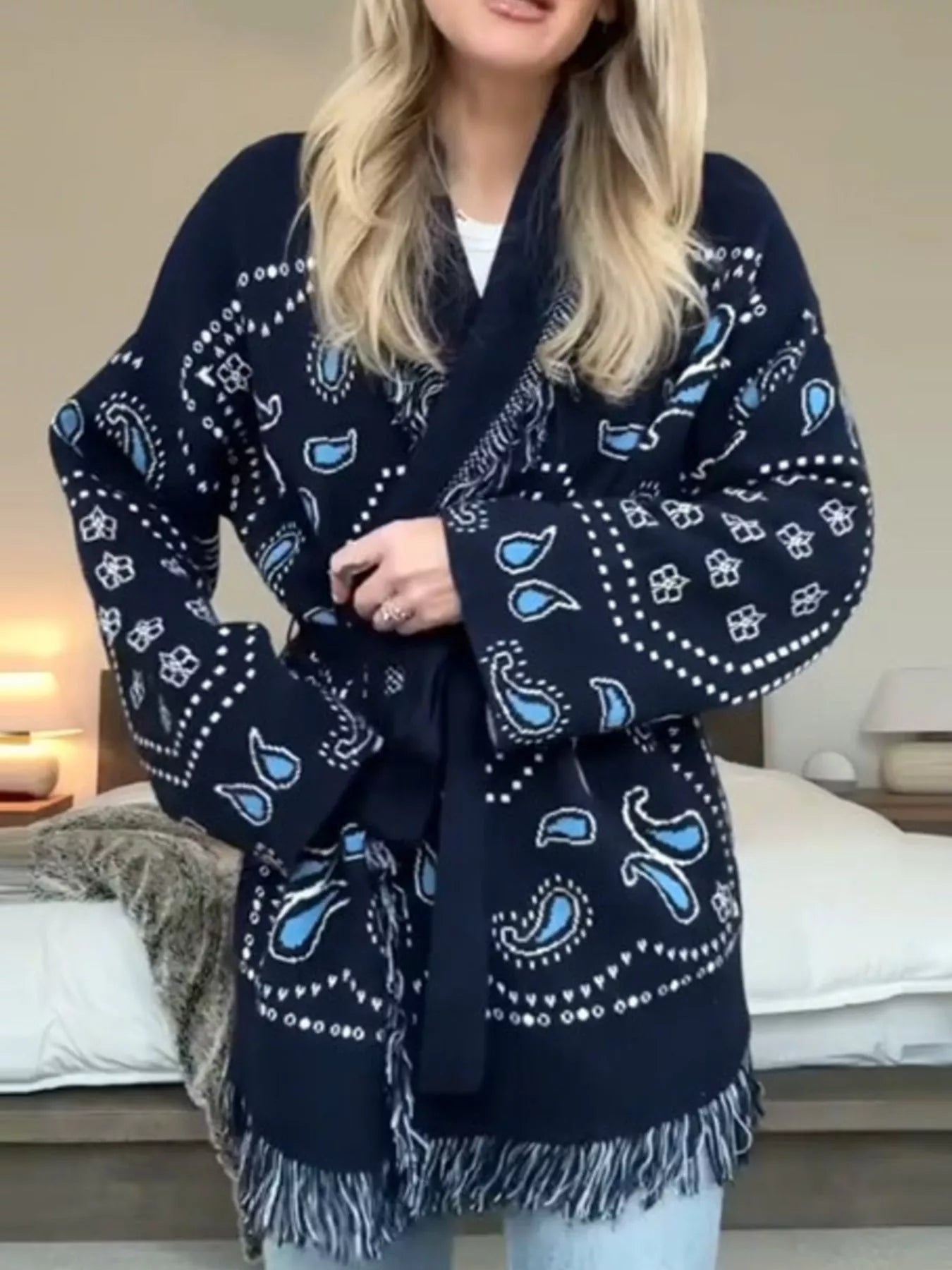 Model wearing a Printed Fringe Long Sleeve Cardigan with blue paisley print and fringe detailing.
