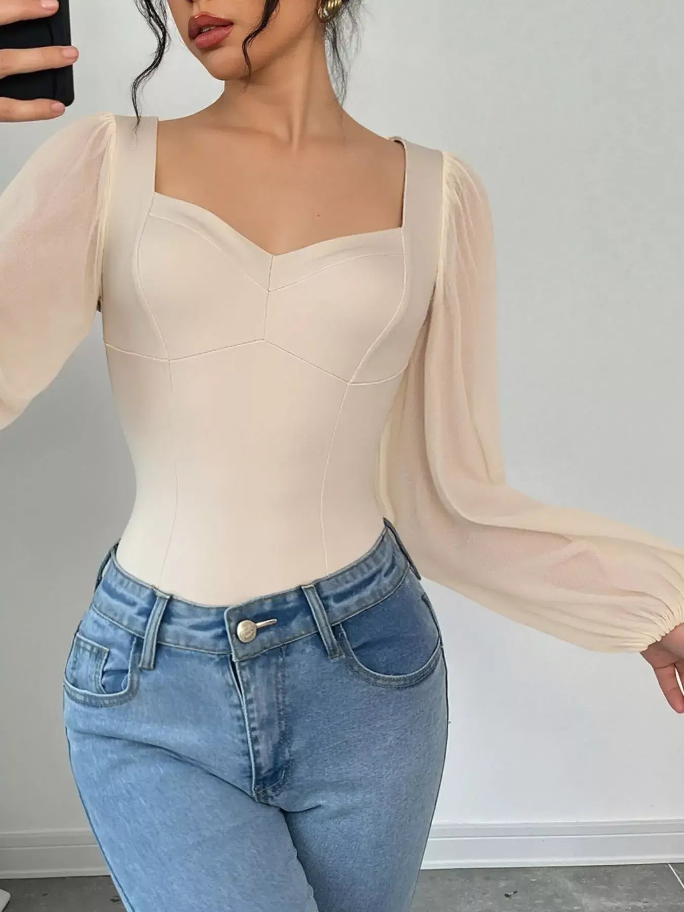 Sweetheart neck balloon sleeve bodysuit in cream color, paired with high-waisted jeans, highlighting its chic fit.