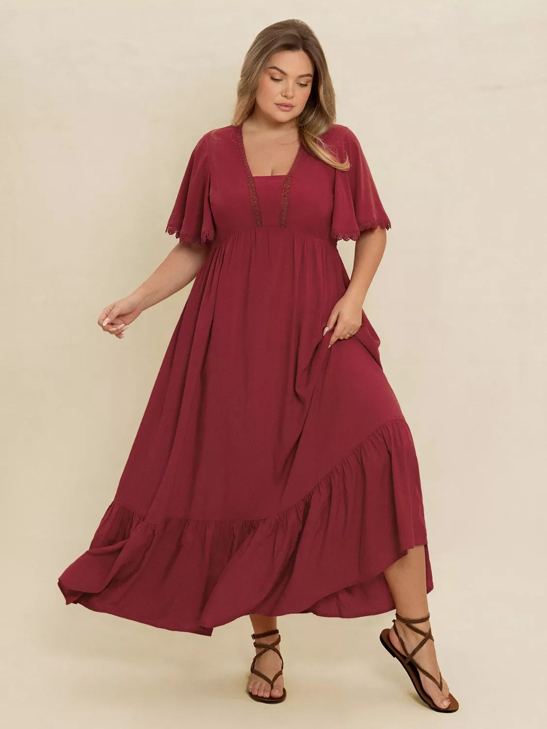 Plus Size Lace Detail Flutter Sleeve Maxi Dress worn by a model in burgundy, showcasing a flowing silhouette and lace accents.