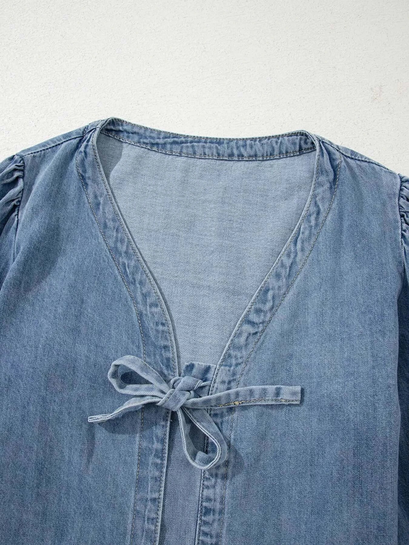 Tied front puff sleeve denim top for women with a chic tie design and soft blue fabric.