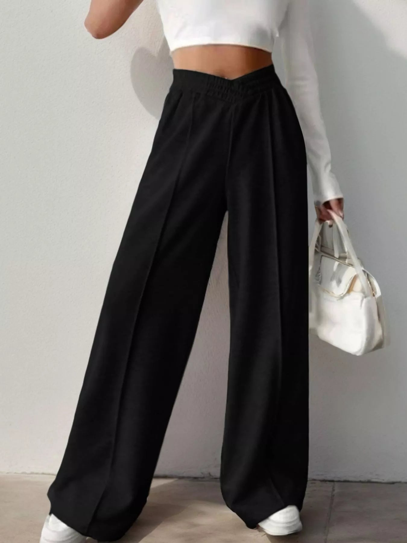 Wide Leg High Waist Pants in black, styled for an elegant everyday look with a fitted top and casual bag.