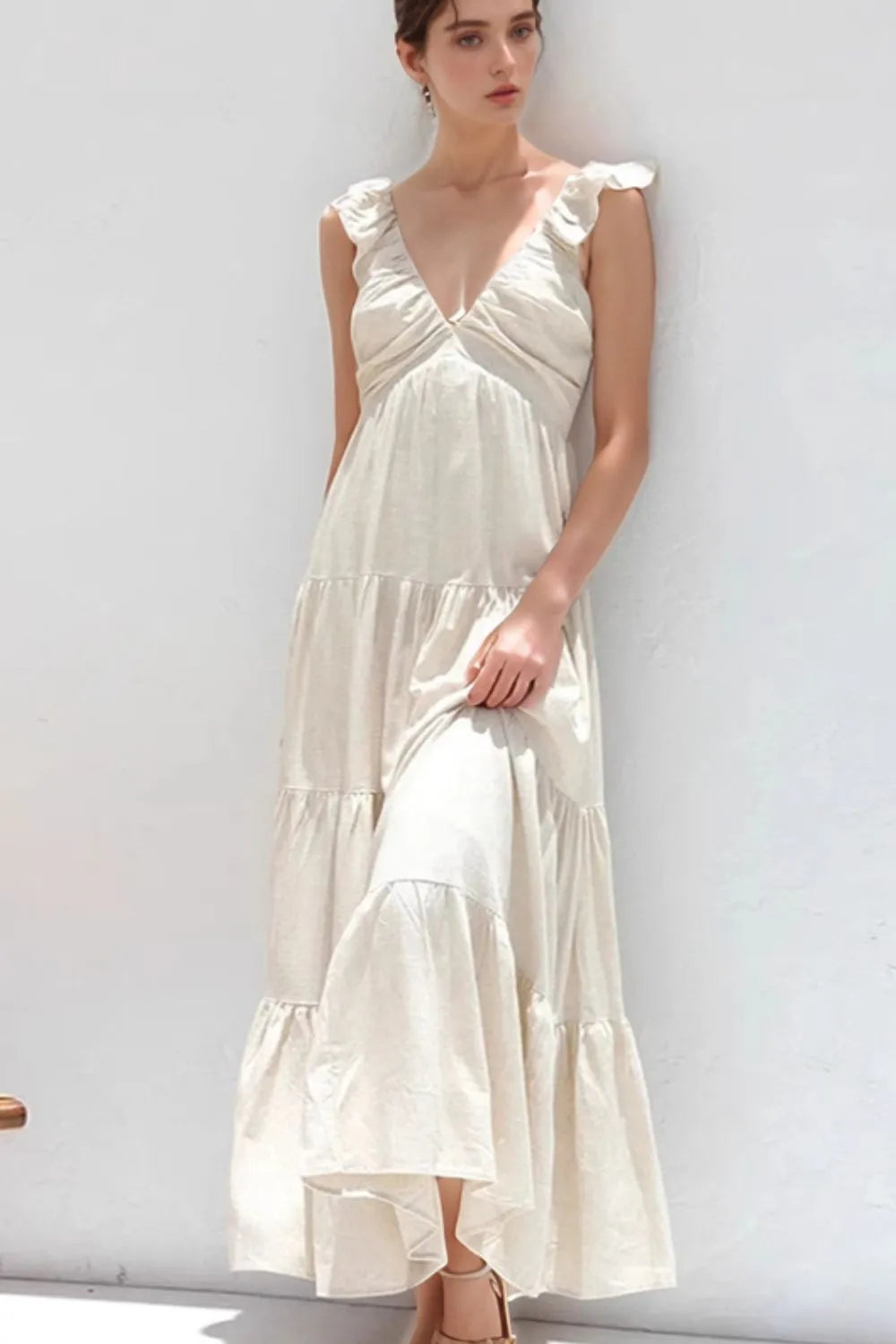 Ruffled V-Neck Tiered Dress displayed on a model, showcasing elegant smocked cotton style in a light color.