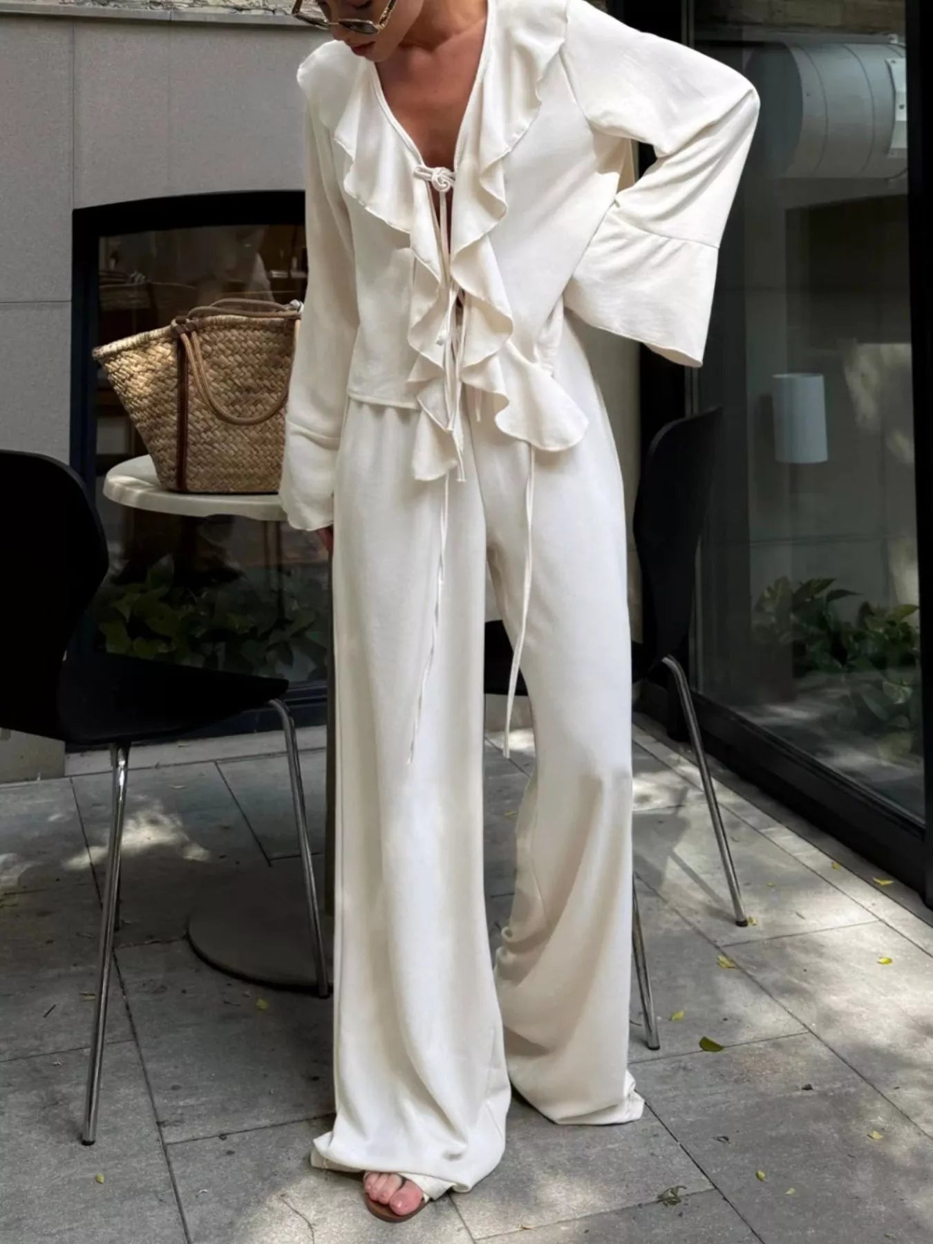 Woman wearing Ruffle Trim Tie Front Top and Pants Set in white, featuring ruffled trim and a tied front detail.