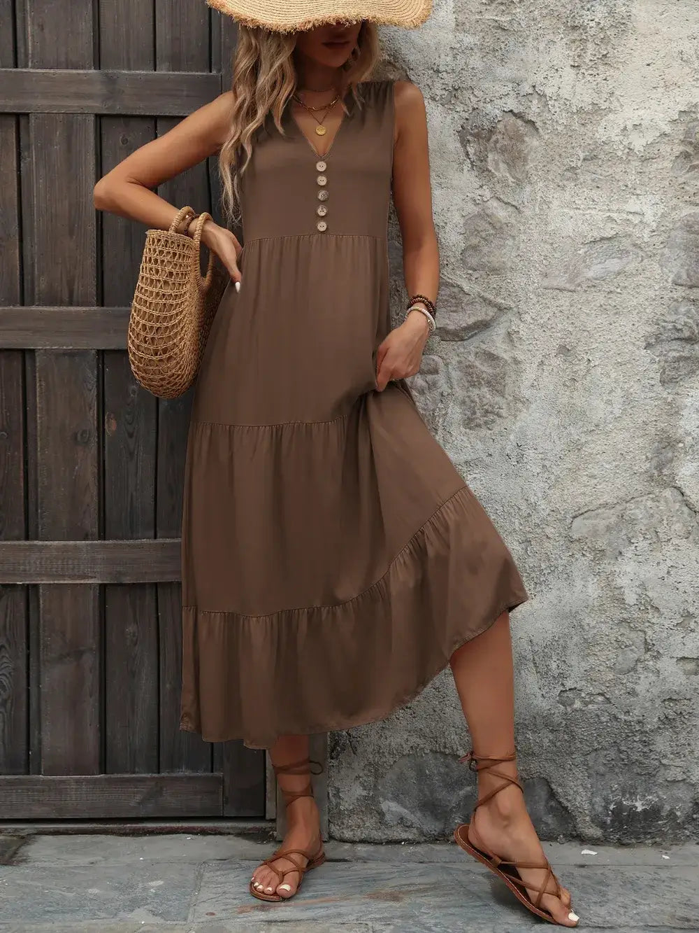 Ivy Lane Decorative Button Notched Sleeveless Dress in brown with buttons and tiered design against a rustic backdrop.