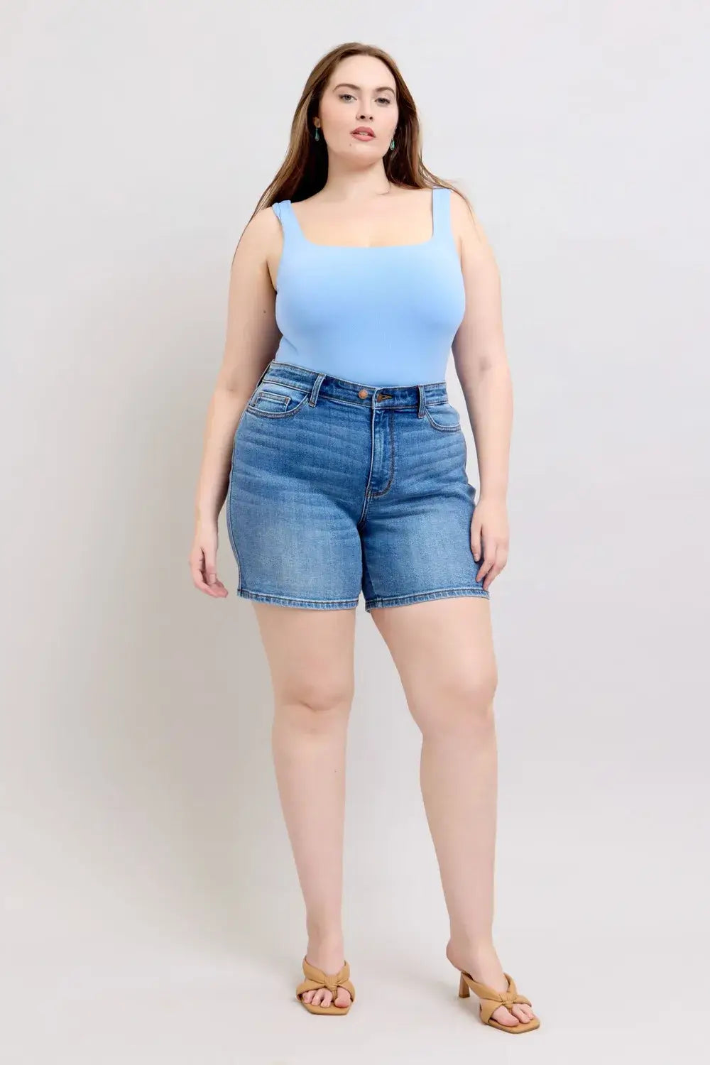 Plus size model wearing Judy Blue denim shorts with light blue tank top, showcasing style and comfort.