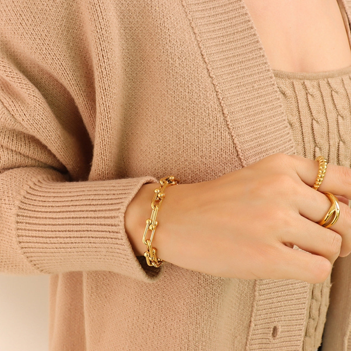 Chunky Chain Titanium Steel Bracelet worn on a woman’s wrist with a soft beige cardigan, showcasing modern style.