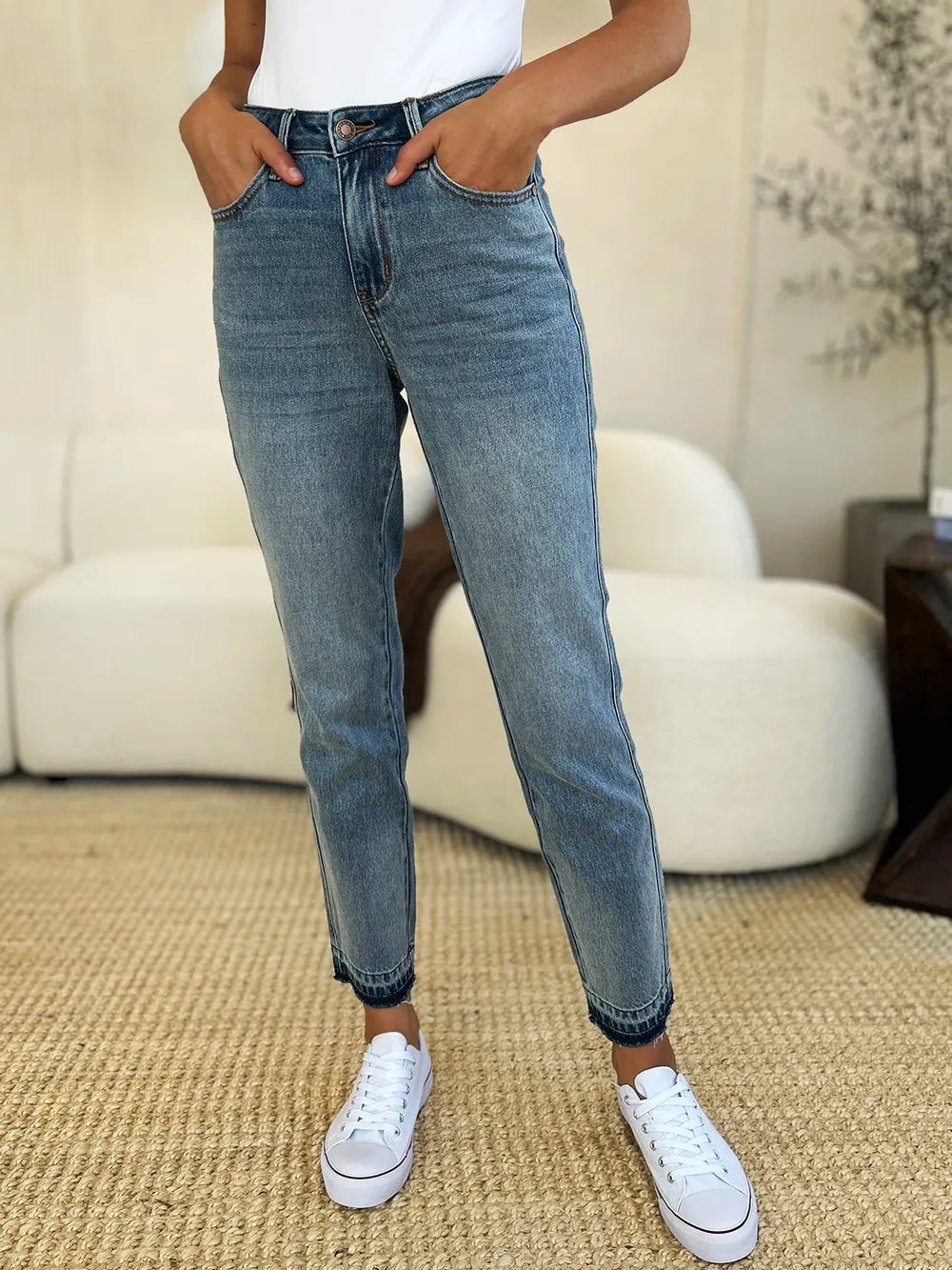 Model wearing Mid Rise Magic Release Hem Jeans with a classic structured fit in a stylish casual outfit.