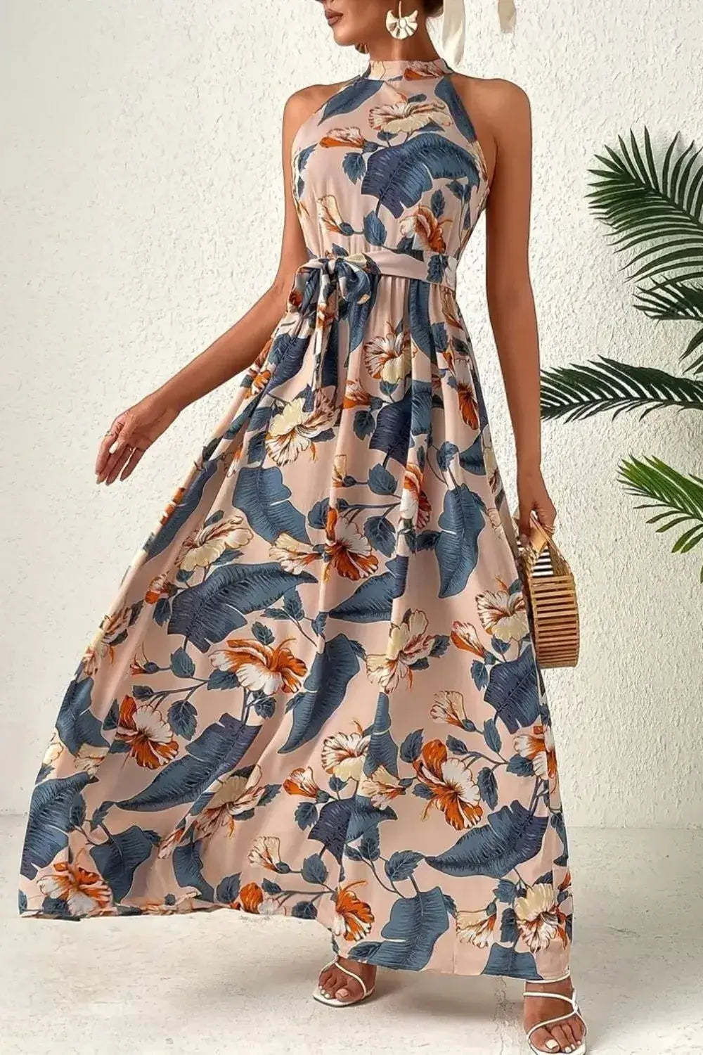 Model showcasing the Tied Floral Sleeveless Dress with a floral pattern, perfect for summer outings.
