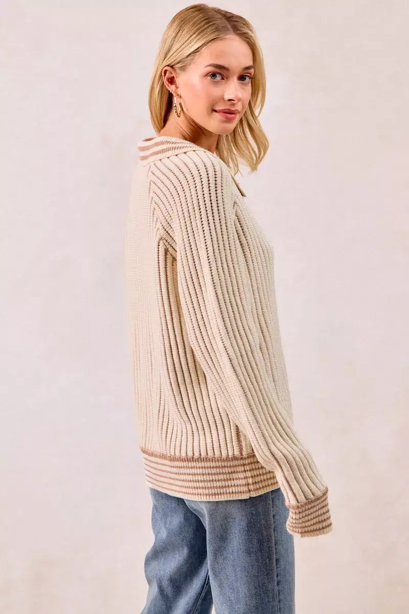 Woman wearing a BiBi half button ribbed two tone sweater, showcasing its cozy and stylish ribbed design.