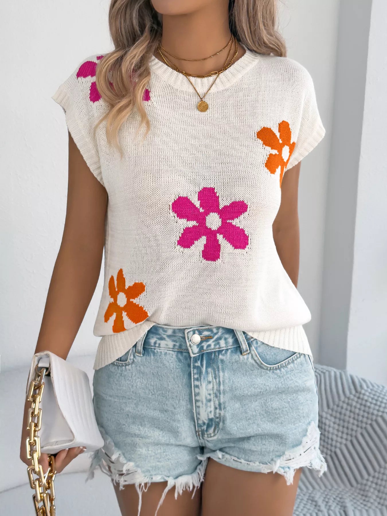 Flower Round Neck Sweater stylishly worn with denim shorts, featuring floral designs in pink and orange.