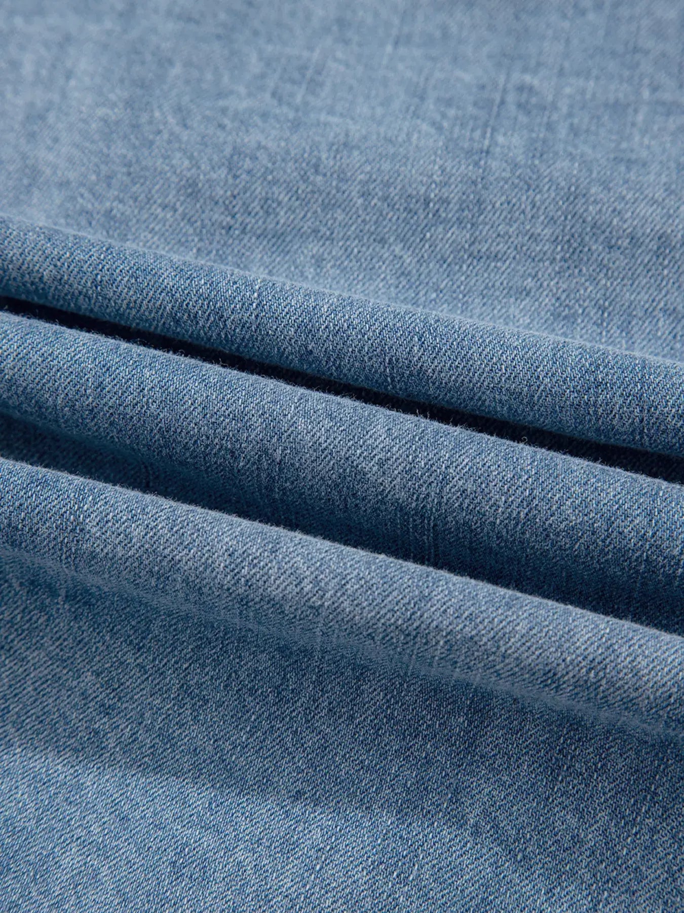 Close-up of soft blue denim fabric, showcasing its texture and quality for a stylish denim blouse.