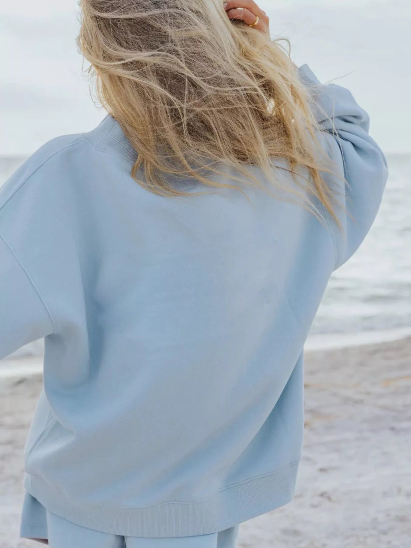 Relaxed Fit Round Neck Sweatshirt and Shorts Set casual style in light blue worn on the beach.