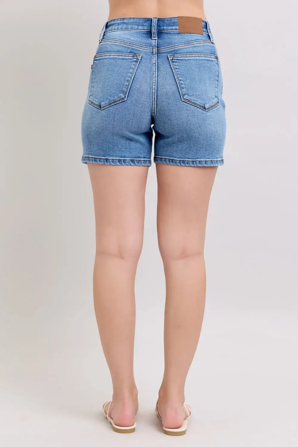 Back view of Judy Blue Plus Size Denim Shorts featuring a 2-button design and pockets in light blue wash.