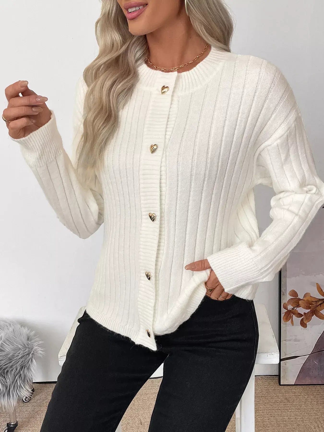 Model wearing a Ribbed Button Up Long Sleeve Cardigan in white with gold buttons, showcasing its cozy and elegant style.