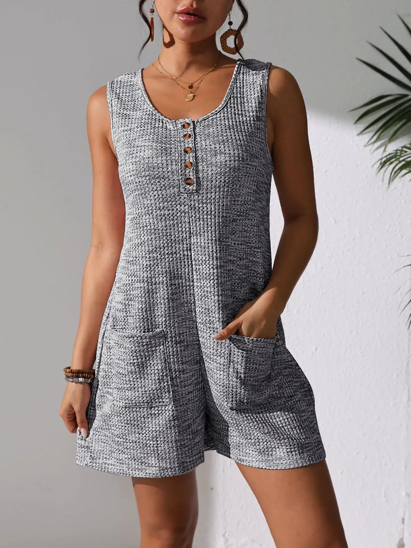 Full Size Button Front Romper with Pockets worn by a model, featuring button detail and functional pockets.