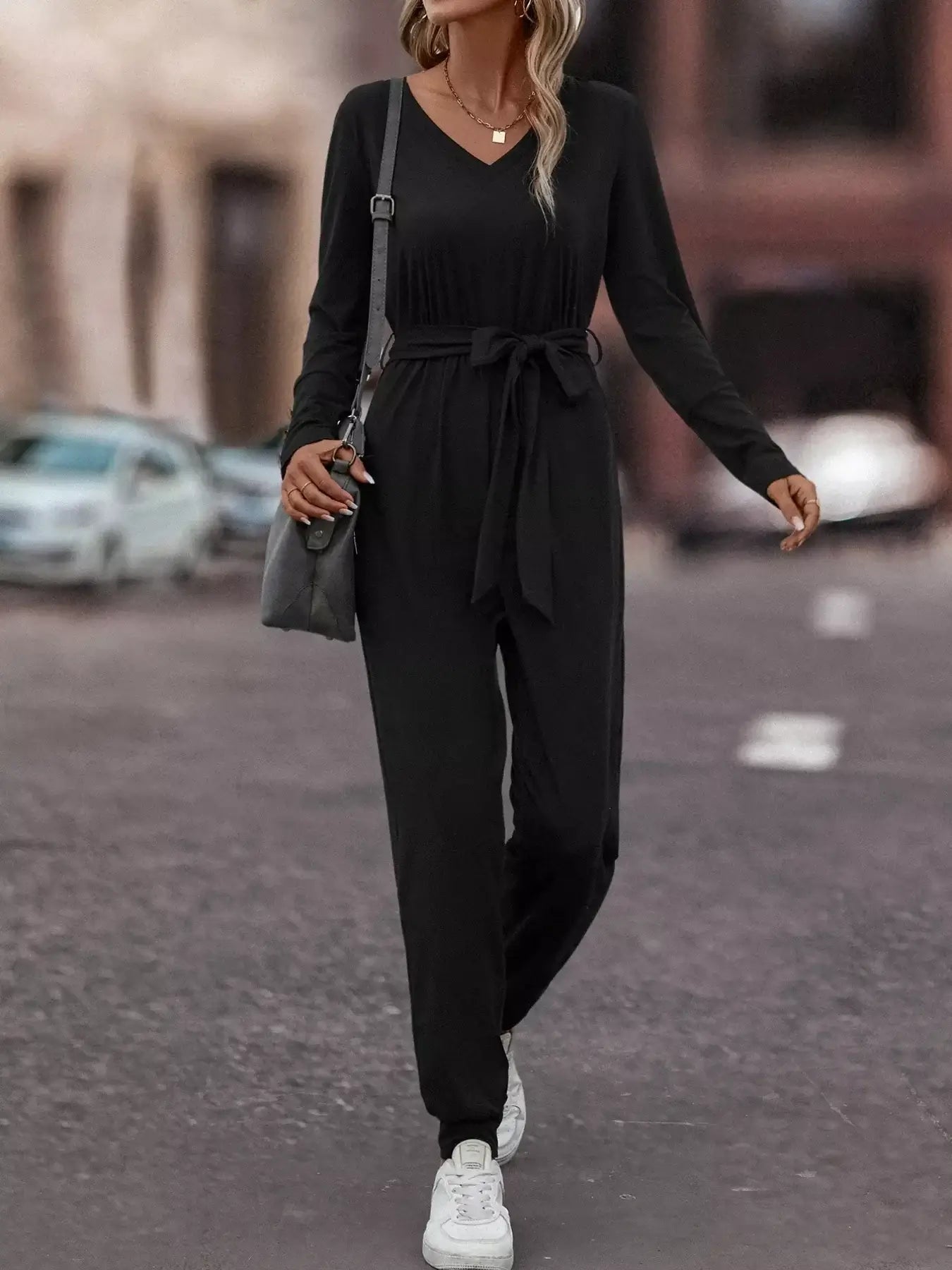 V-Neck Long Sleeve Tie Waist Jumpsuit for Women worn with sneakers in a stylish outdoor setting.