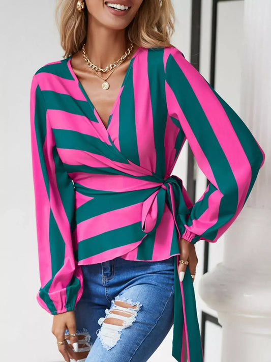 Striped wrap blouse with tie detail in pink and green, featuring long sleeves and a flattering wrap design.