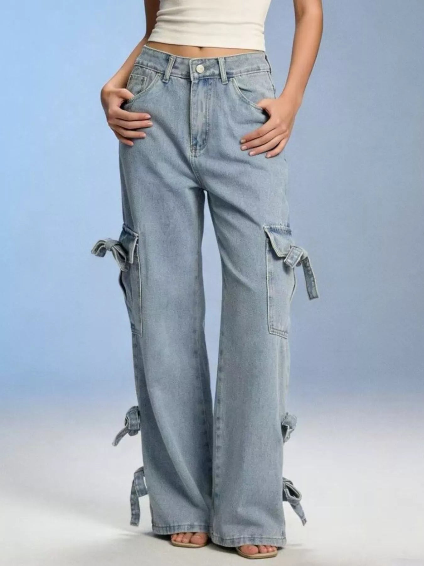 Model wearing Bow Wide Leg Jeans with pocketed detail and a relaxed fit, showcasing the light blue fabric and tied accents.