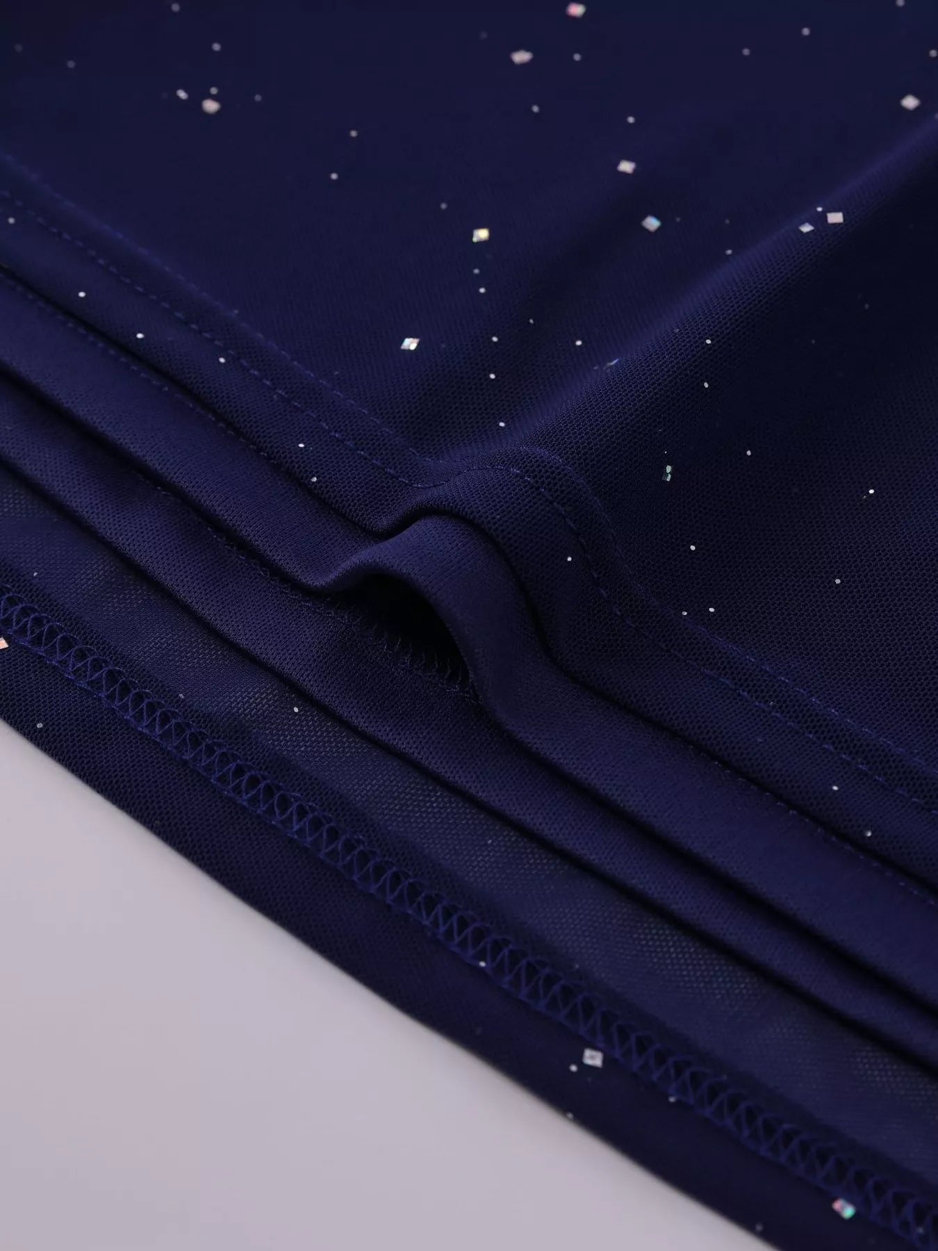 Close-up of the glitter detail on the Glitter Off-Shoulder Maxi Dress showcasing its shimmering design.