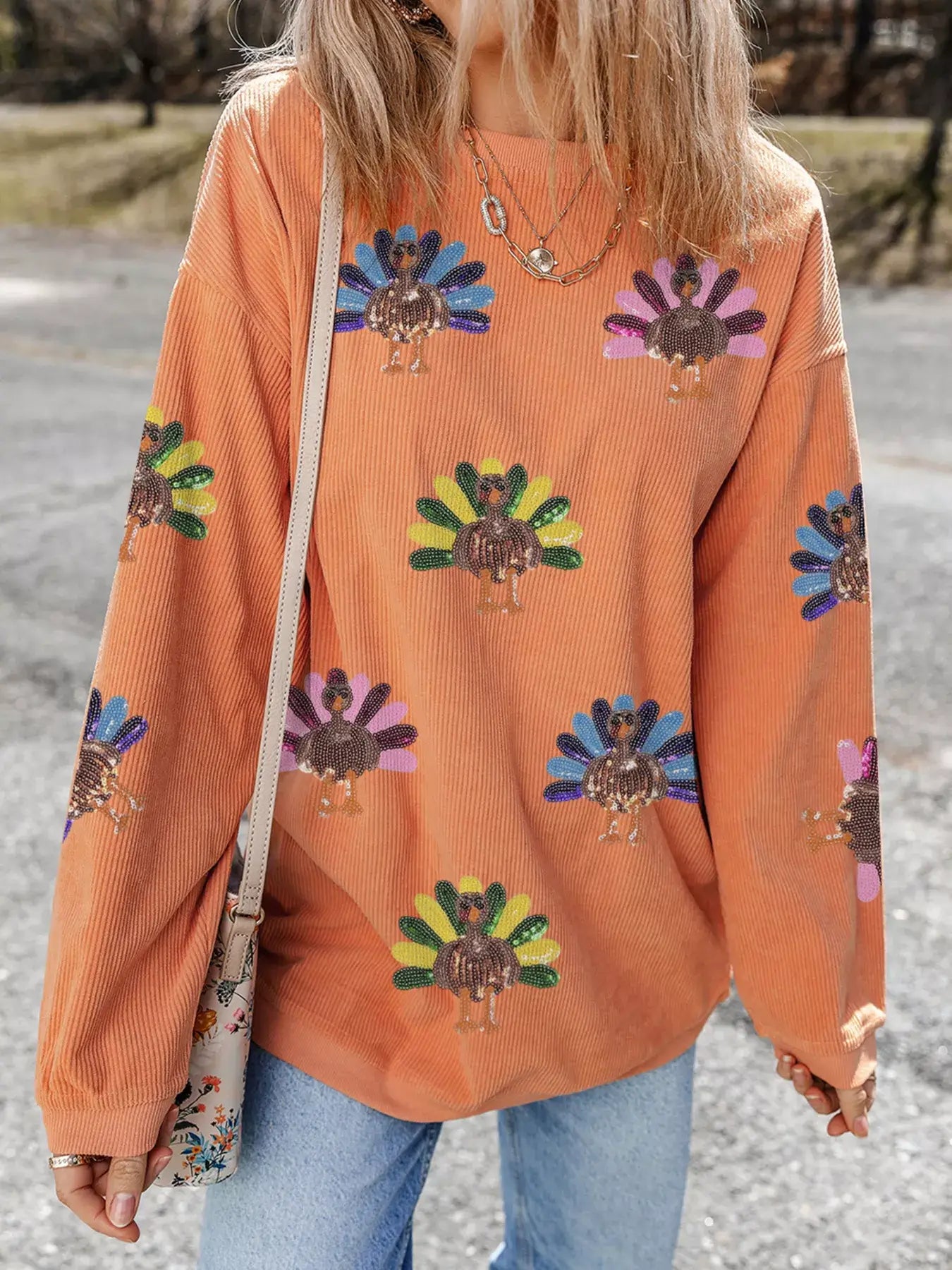 Turkey Graphic Corded Baggy Sweatshirt featuring a colorful turkey graphic on a cozy orange background.