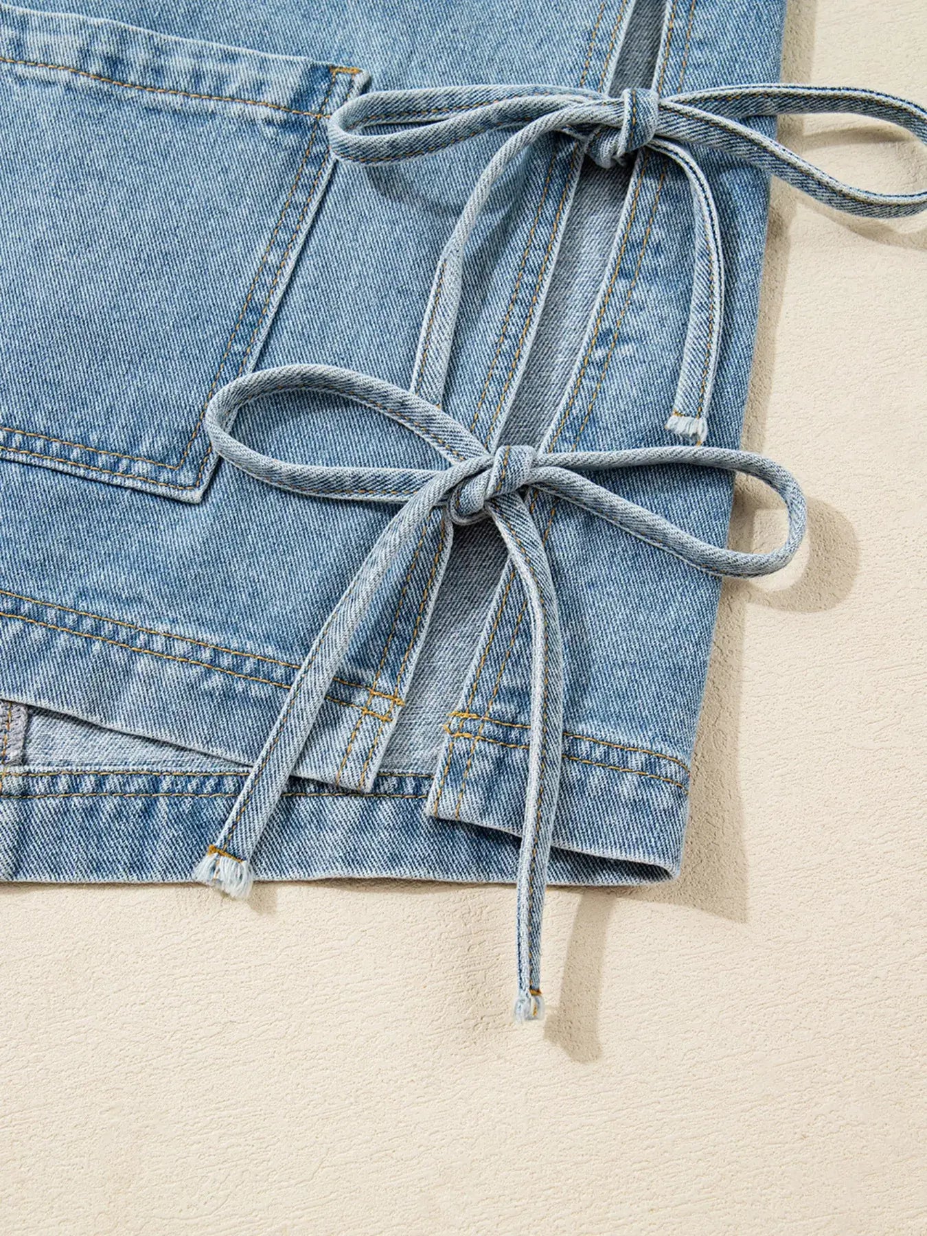 Close-up of side tie detail on a Patched Pockets Denim Jacket for women, showcasing stylish knot and denim texture.