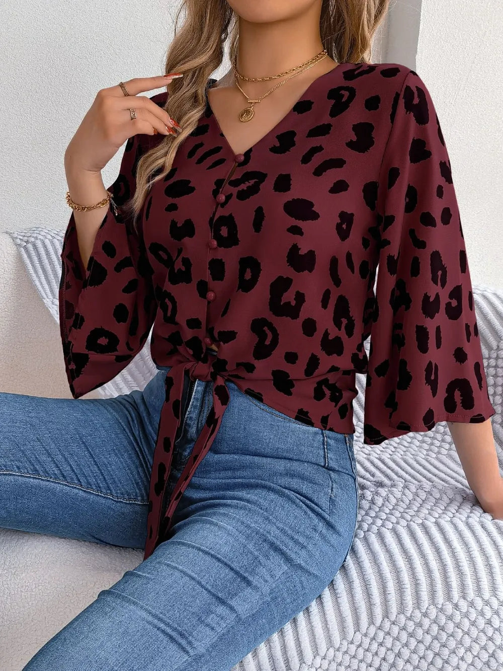 Tied Button Up Leopard V-Neck Blouse worn with jeans, featuring a tied front and stylish leopard print design.