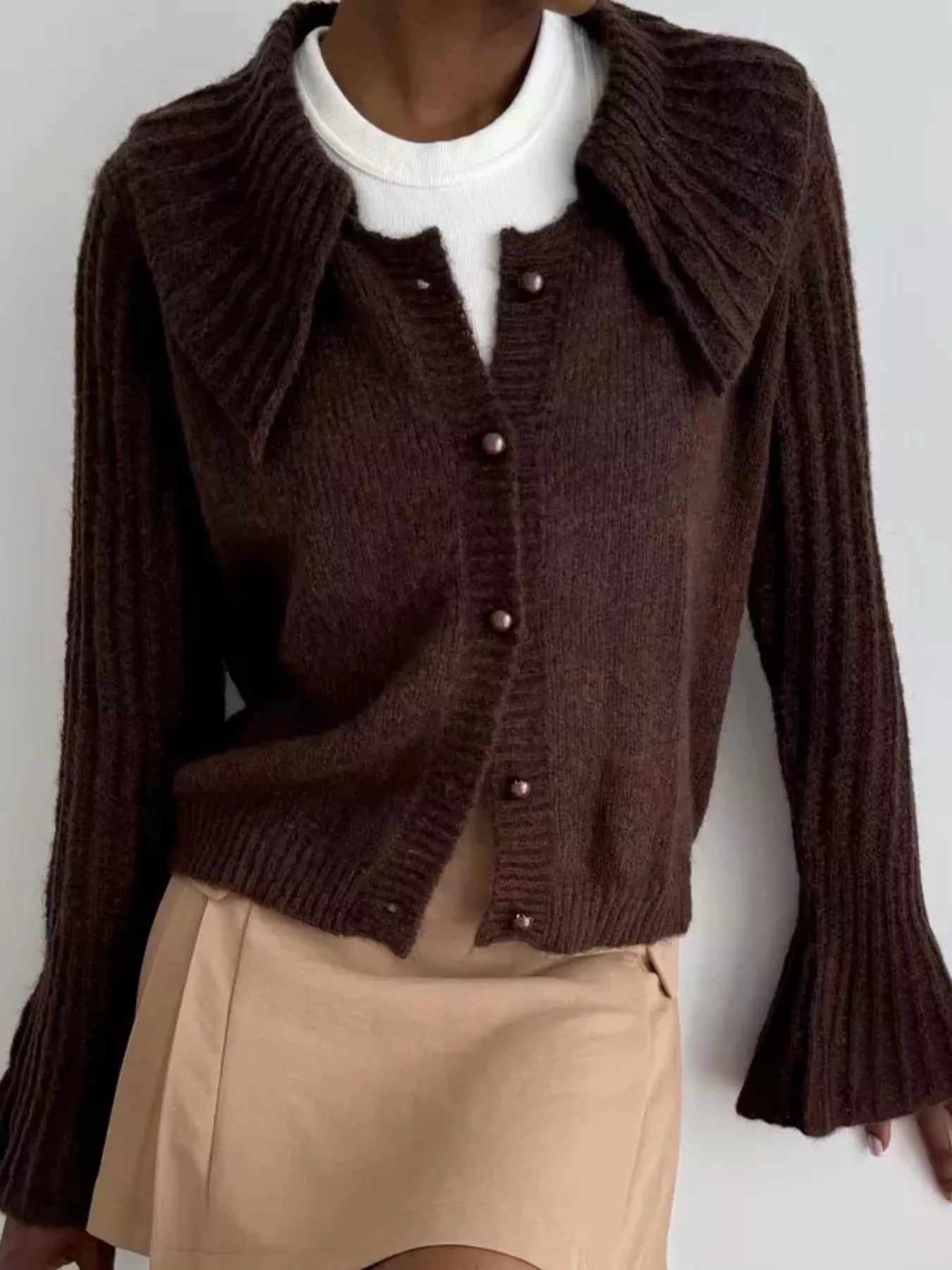 Button Up Flare Sleeve Cardigan in brown with button details and ribbed texture, styled casually with a white top and skirt.