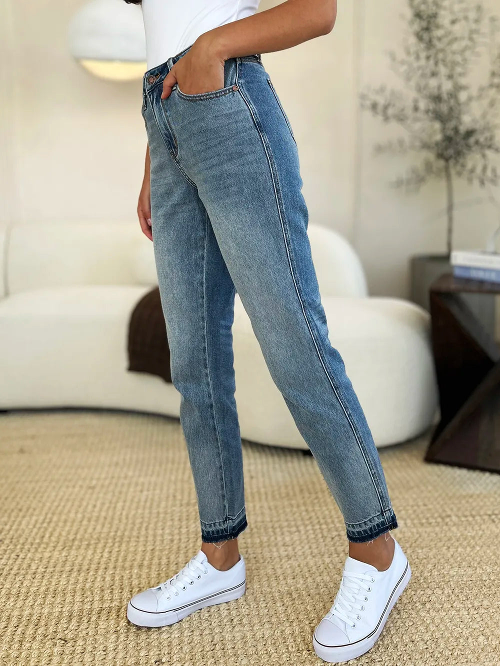 Mid Rise Magic Release Hem Jeans worn by a model with white sneakers, showcasing a structured fit and stylish design.