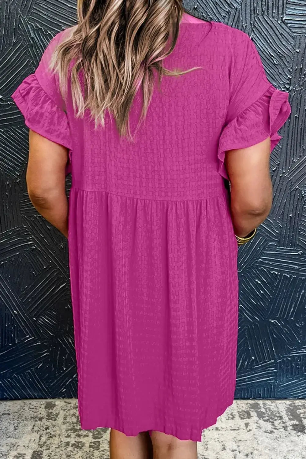 Back view of a woman wearing a pink Round Neck Flounce Sleeve Mini Dress with ruffled sleeves.