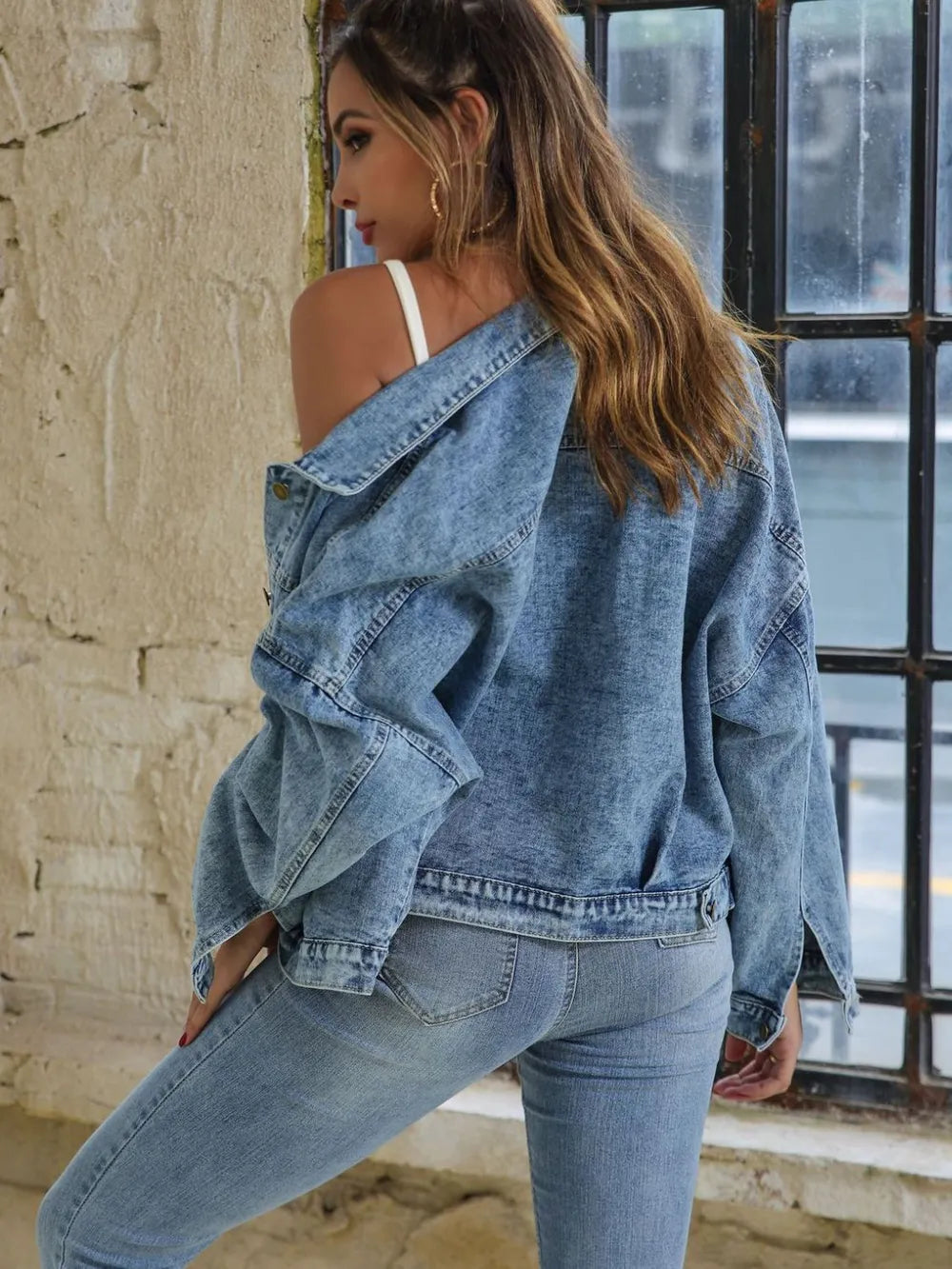 Woman wearing a Button Down Drop Shoulder Denim Jacket styled for casual layering, showcasing a relaxed fit and blue denim.