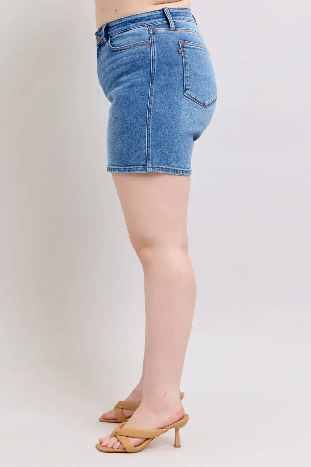 Side view of plus size Judy Blue denim shorts with pockets, showcasing a flattering fit and moderate stretch.