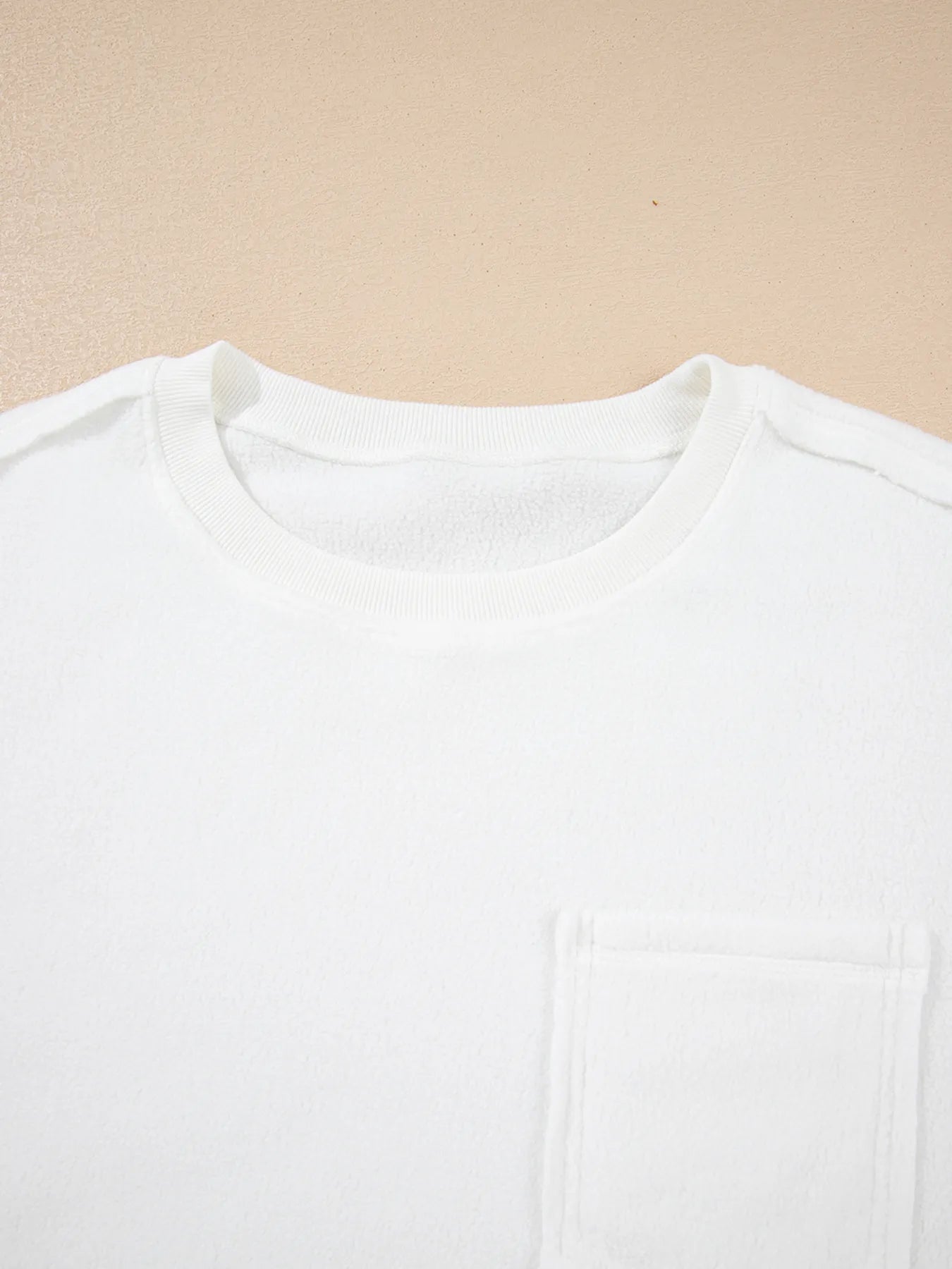 Exposed Seam Chest Pocket Knit Pullover Sweatshirt featuring a round neck and white fabric with chest pocket detail.