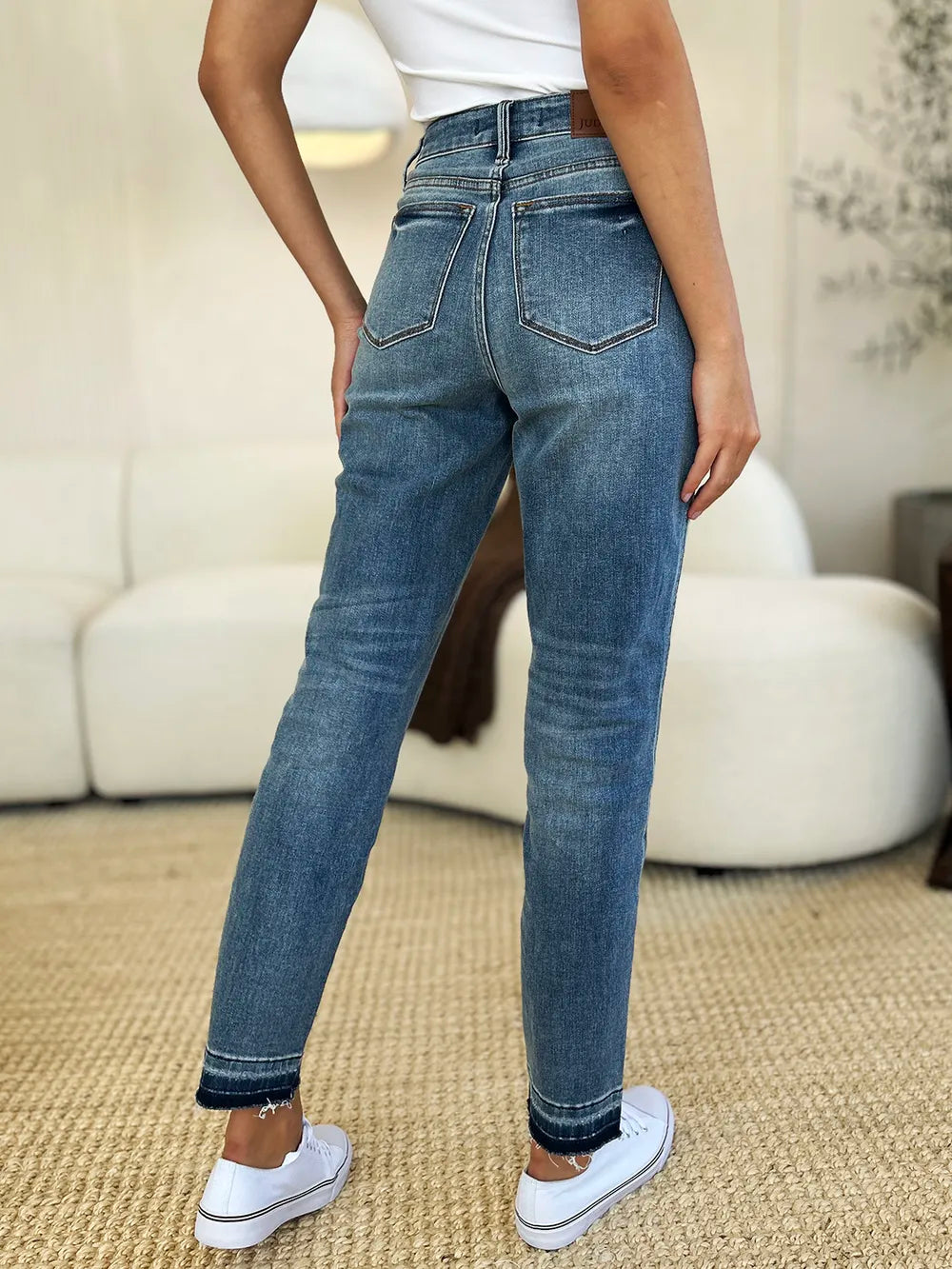 Mid Rise Magic Release Hem Jeans – Classic Structured Fit shown from the back, styled with a casual white top and sneakers.