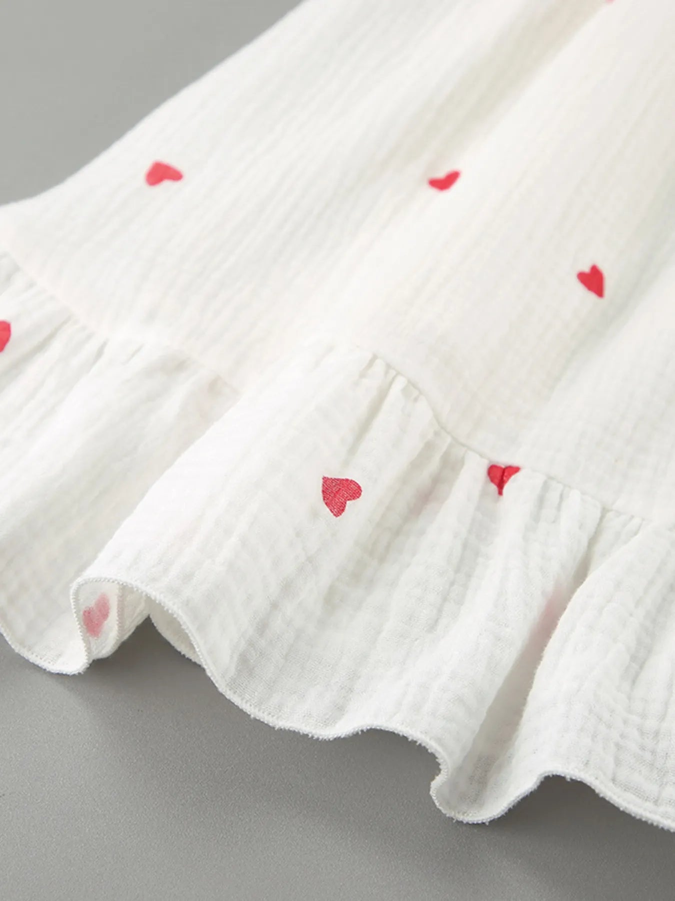 Heart Printed Off-Shoulder Ruffle Mini Dress with red heart designs on a flowing white fabric.
