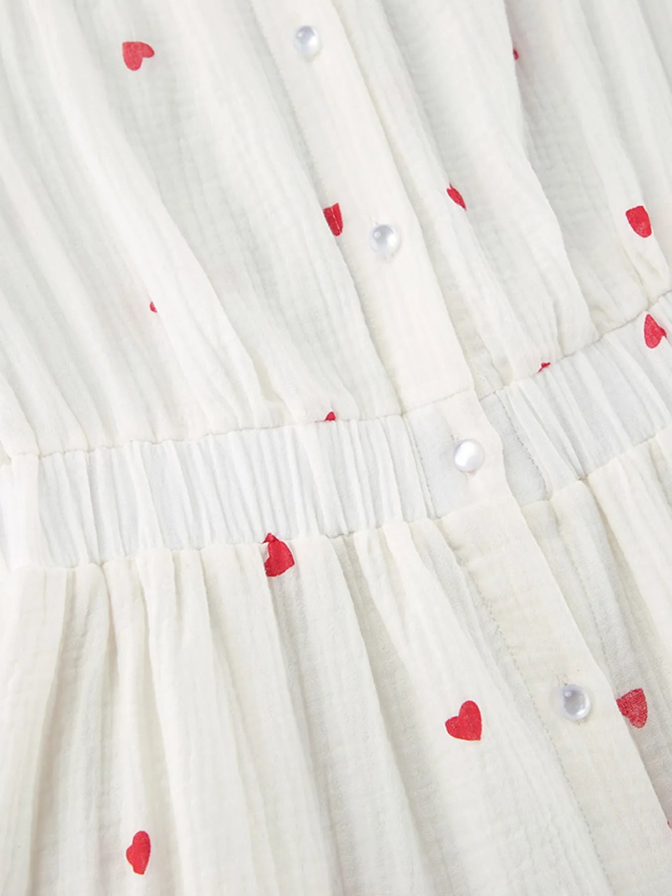 Close-up of fabric featuring small red hearts on Heart Printed Off-Shoulder Ruffle Mini Dress.