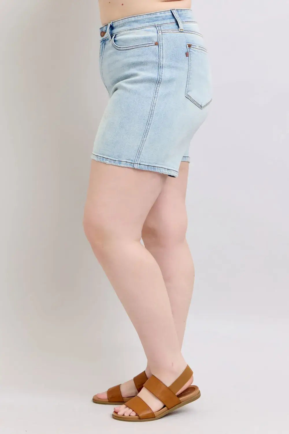Judy Blue Plus Size Denim Shorts in light wash, featuring a 2-button closure and pockets, styled with sandals.